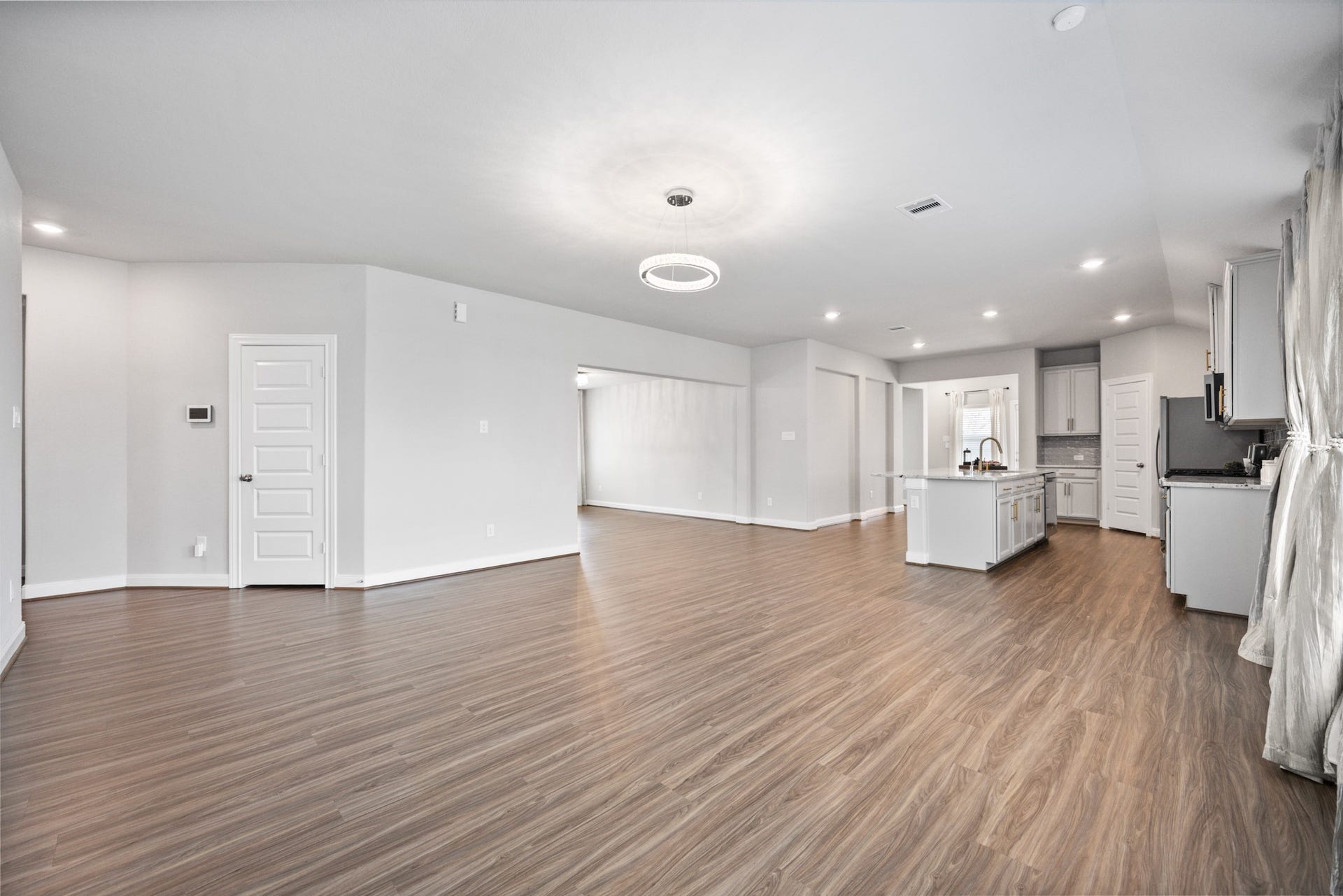 11403 Brookside Arbor Lane, Richmond, TX 77406 The living room integrates seamlessly with the open kitchen and dining area. Note the further convenience of the well-located hall closet and integrated wall plugs for optimal TV placement.
