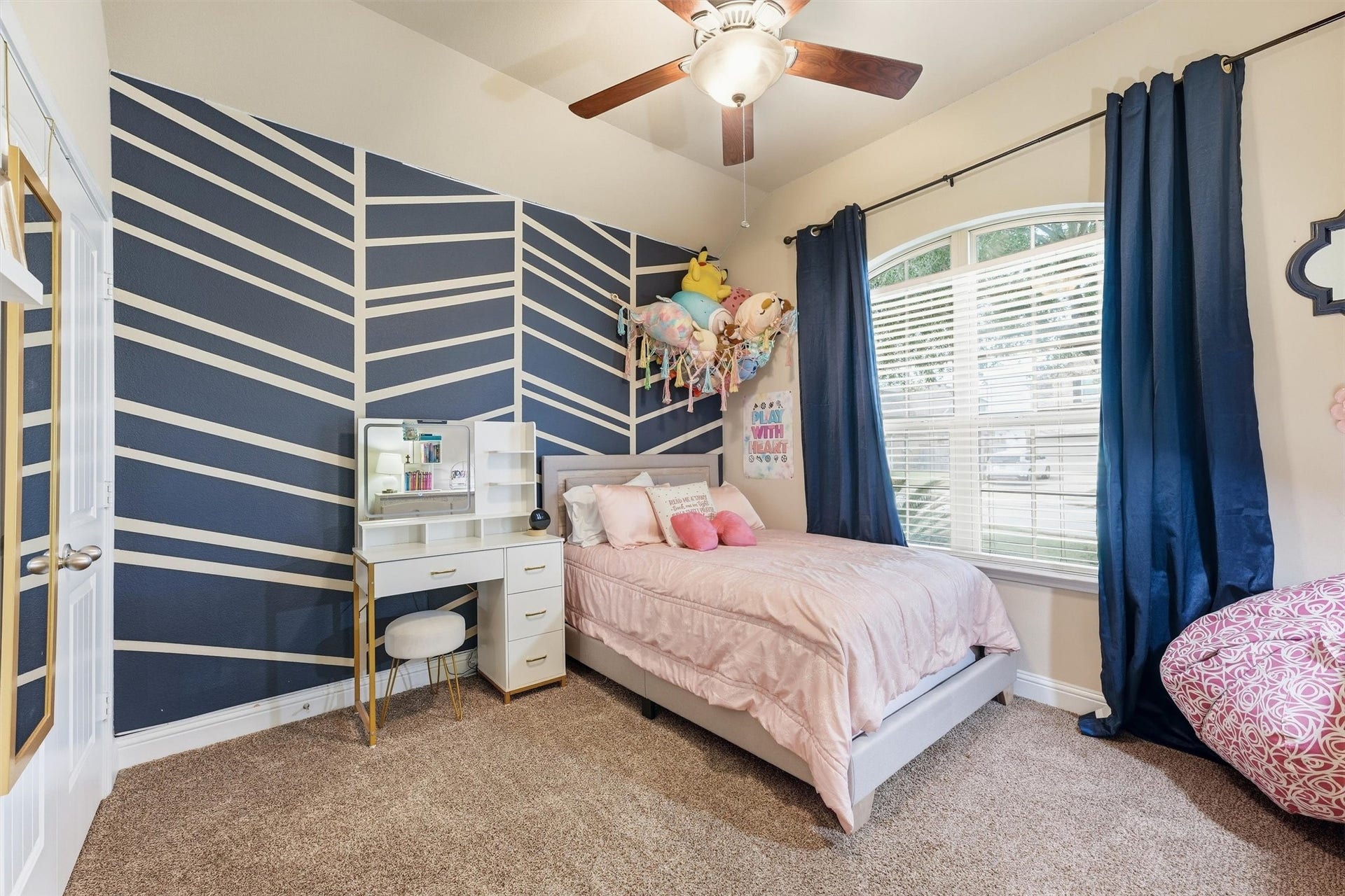 1413 Silver Rings Court, Pearland, TX 77581 Charming bedroom with a unique geometric accent wall, cozy carpeting, and large window offering ample natural light. Perfect for relaxation and creativity.