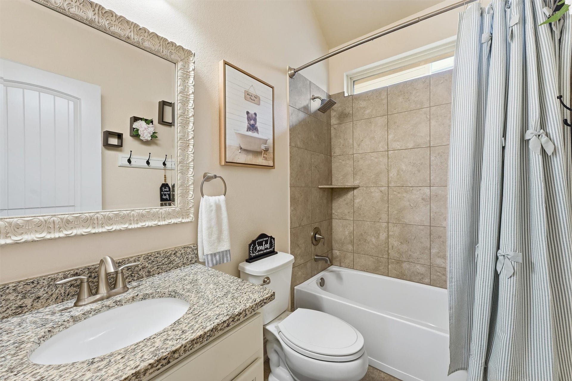 1413 Silver Rings Court, Pearland, TX 77581 Charming bathroom with elegant granite countertops, a decorative framed mirror, and a tiled shower-tub combo.