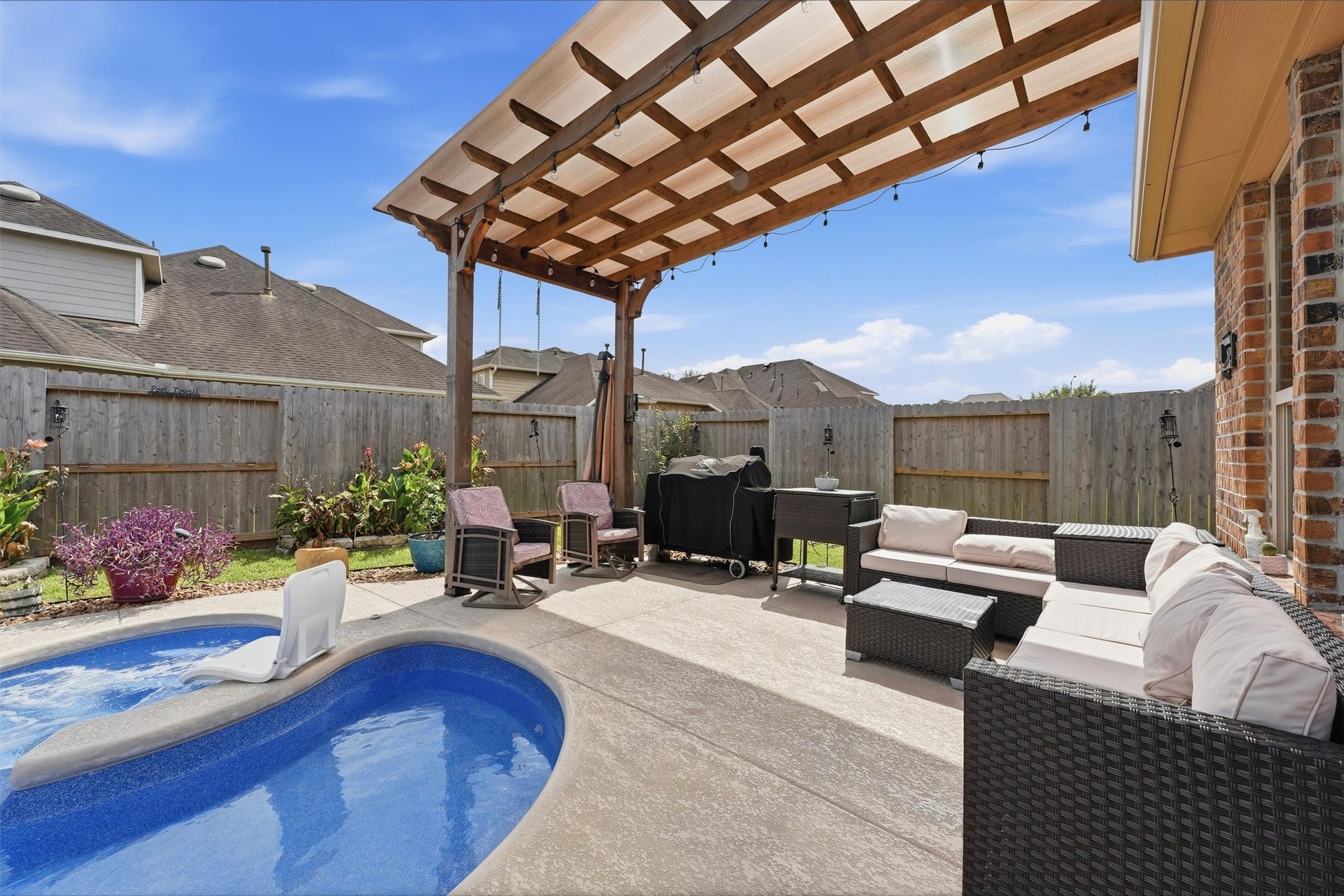 1413 Silver Rings Court, Pearland, TX 77581 A serene backyard oasis featuring a sparkling pool, a stylish pergola - perfect for outdoor entertaining.