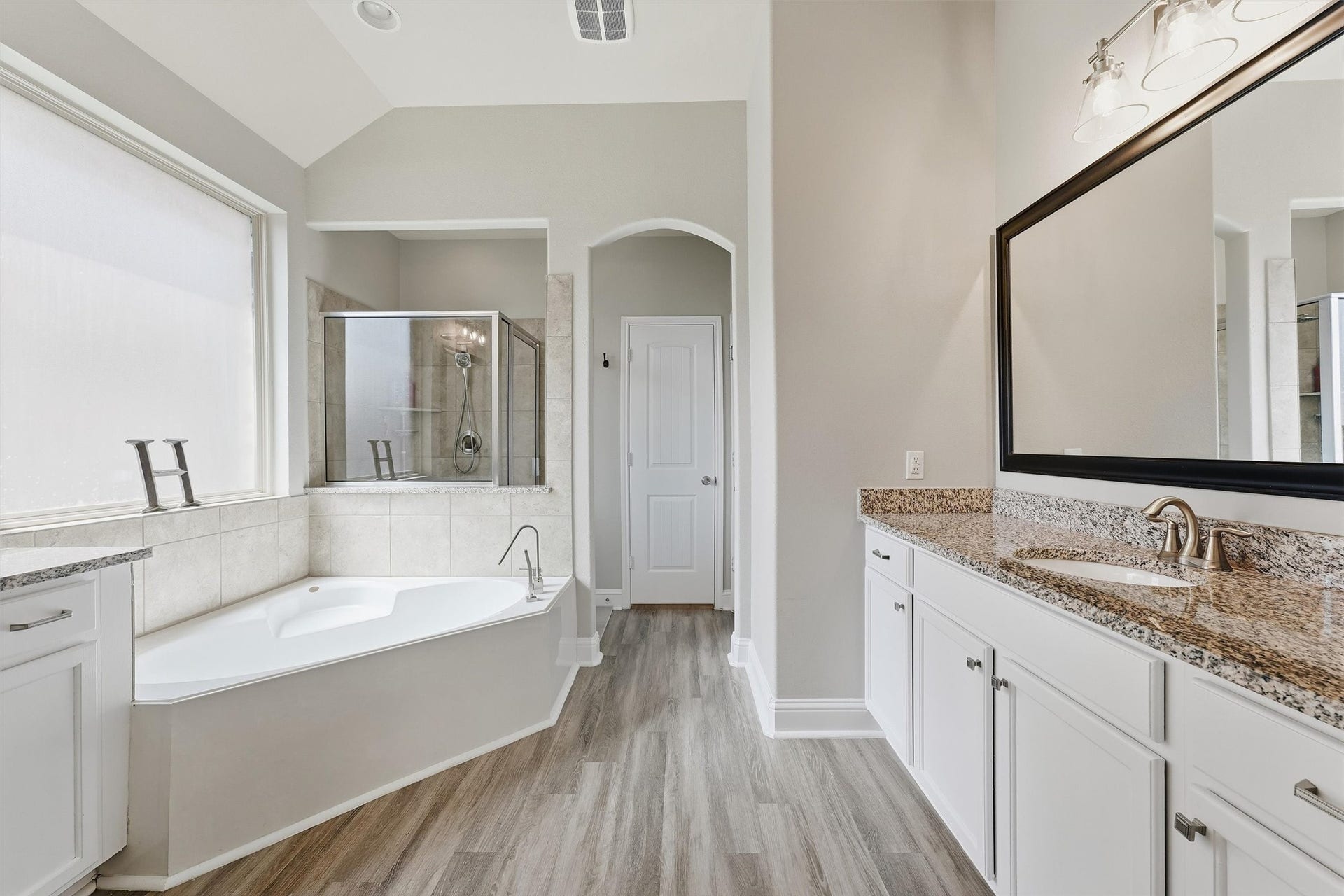 1413 Silver Rings Court, Pearland, TX 77581 Spacious primary bathroom featuring a luxurious soaking tub, separate glass-enclosed shower, dual sinks with granite countertops, and elegant flooring.