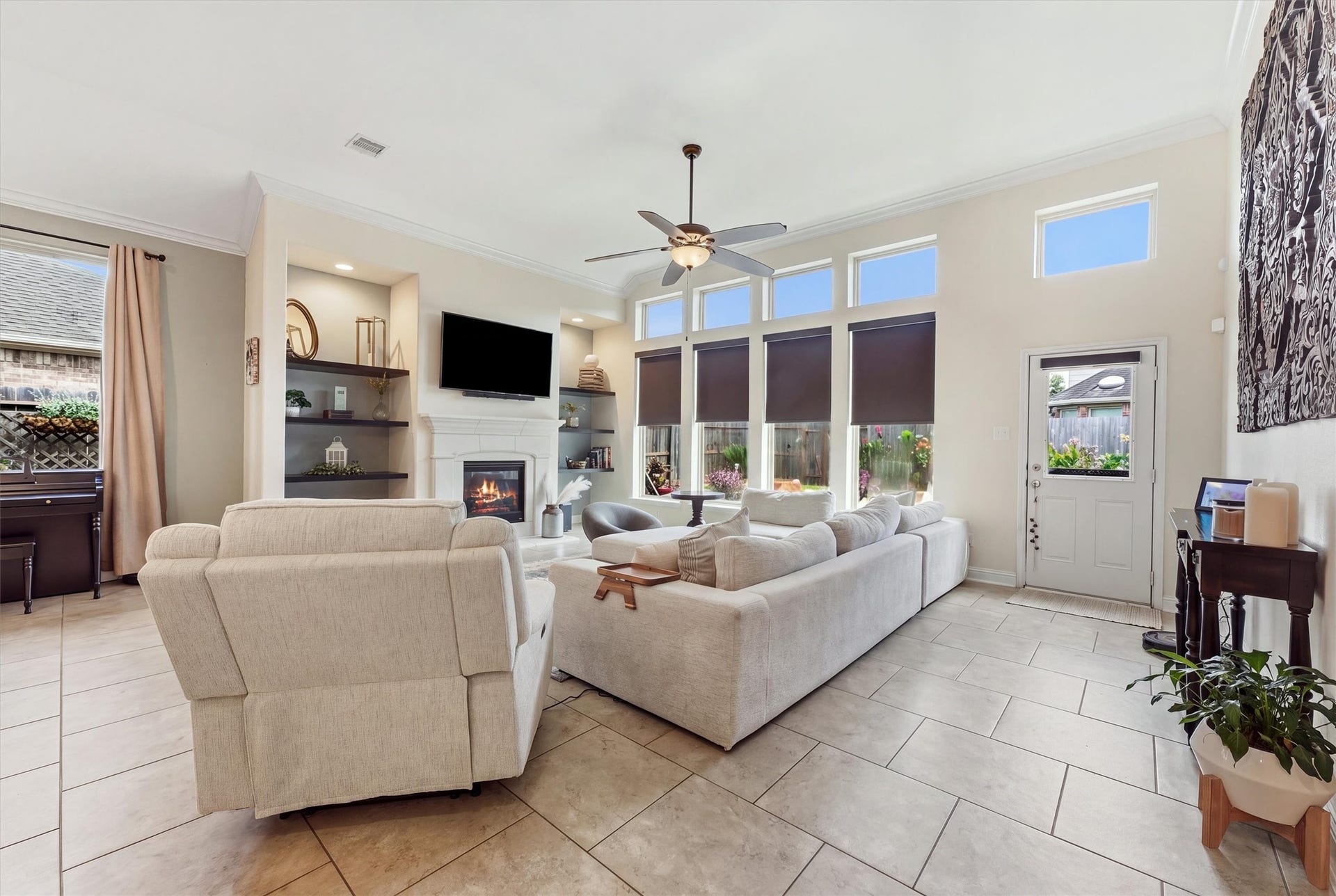1413 Silver Rings Court, Pearland, TX 77581 Experience cozy elegance in this spacious living room, where natural light cascades through tall windows and a gas log fireplace adds a warm, inviting touch.