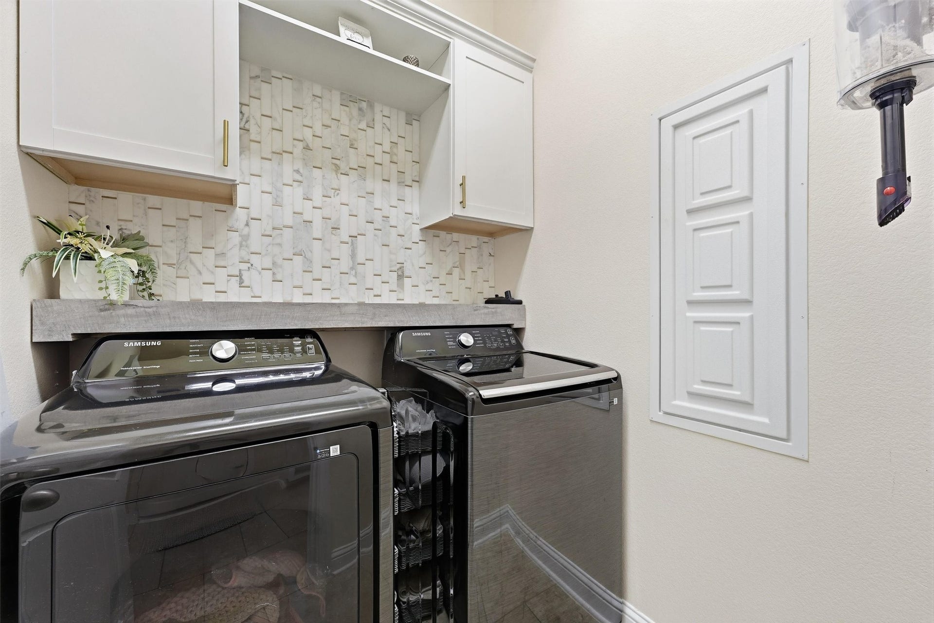 1413 Silver Rings Court, Pearland, TX 77581 Modern laundry room with stylish tile backsplash and ample storage in white cabinetry.