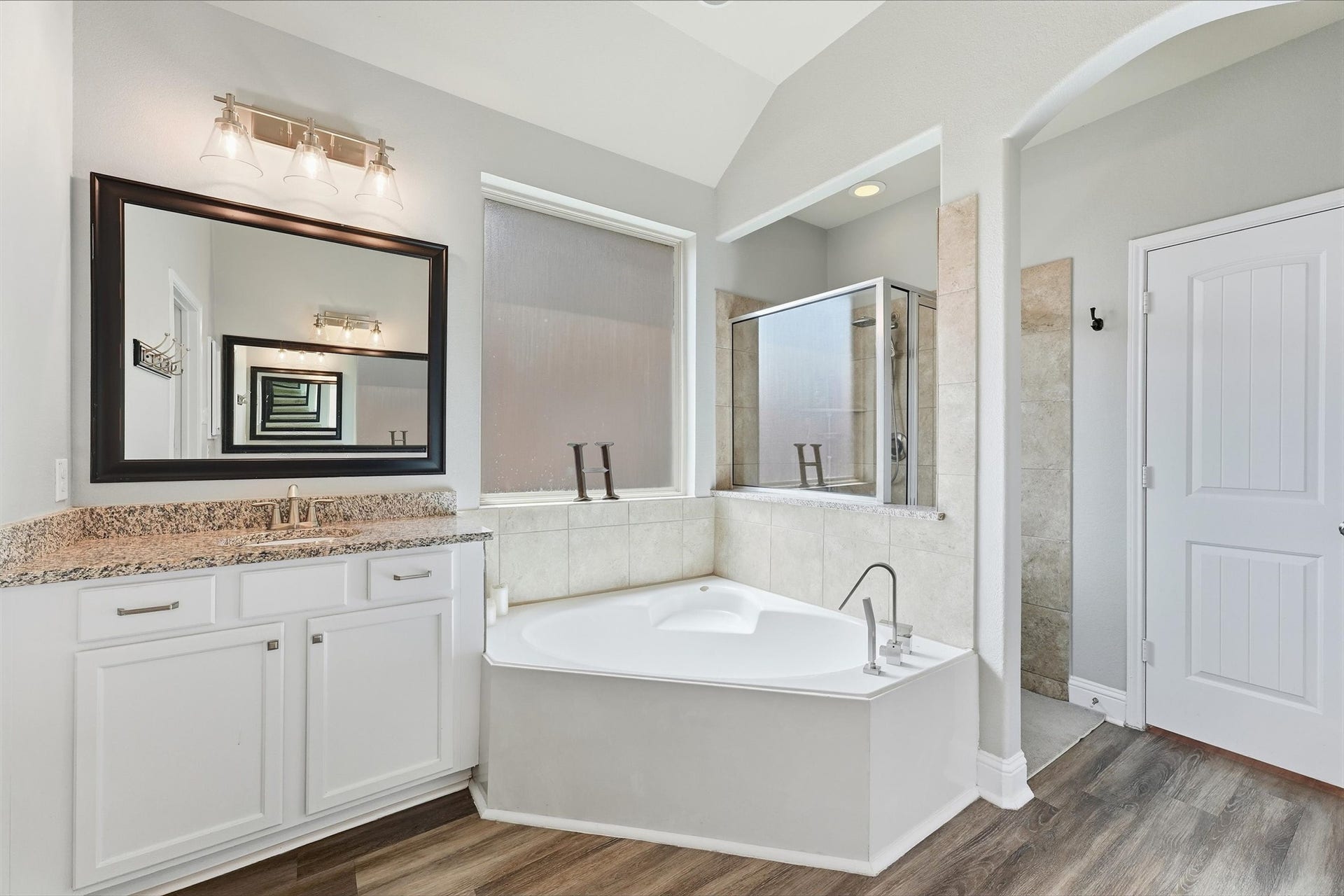1413 Silver Rings Court, Pearland, TX 77581 Luxurious bathroom featuring a relaxing corner soaking tub, elegant granite countertops, and a spacious glass-enclosed shower.