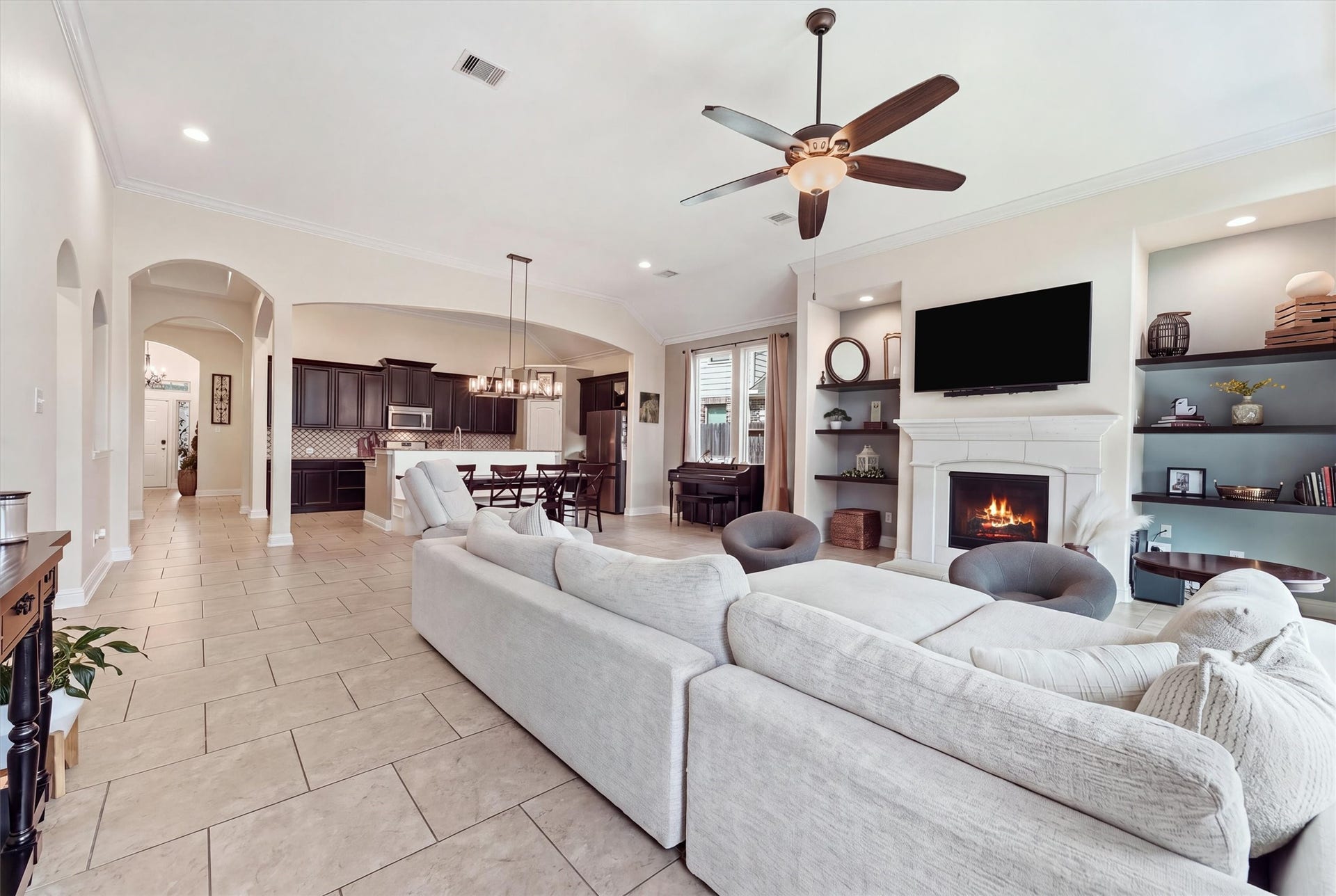 1413 Silver Rings Court, Pearland, TX 77581 Experience cozy elegance with an inviting living area featuring a gas log fireplace, seamlessly flowing into a modern kitchen and dining space.