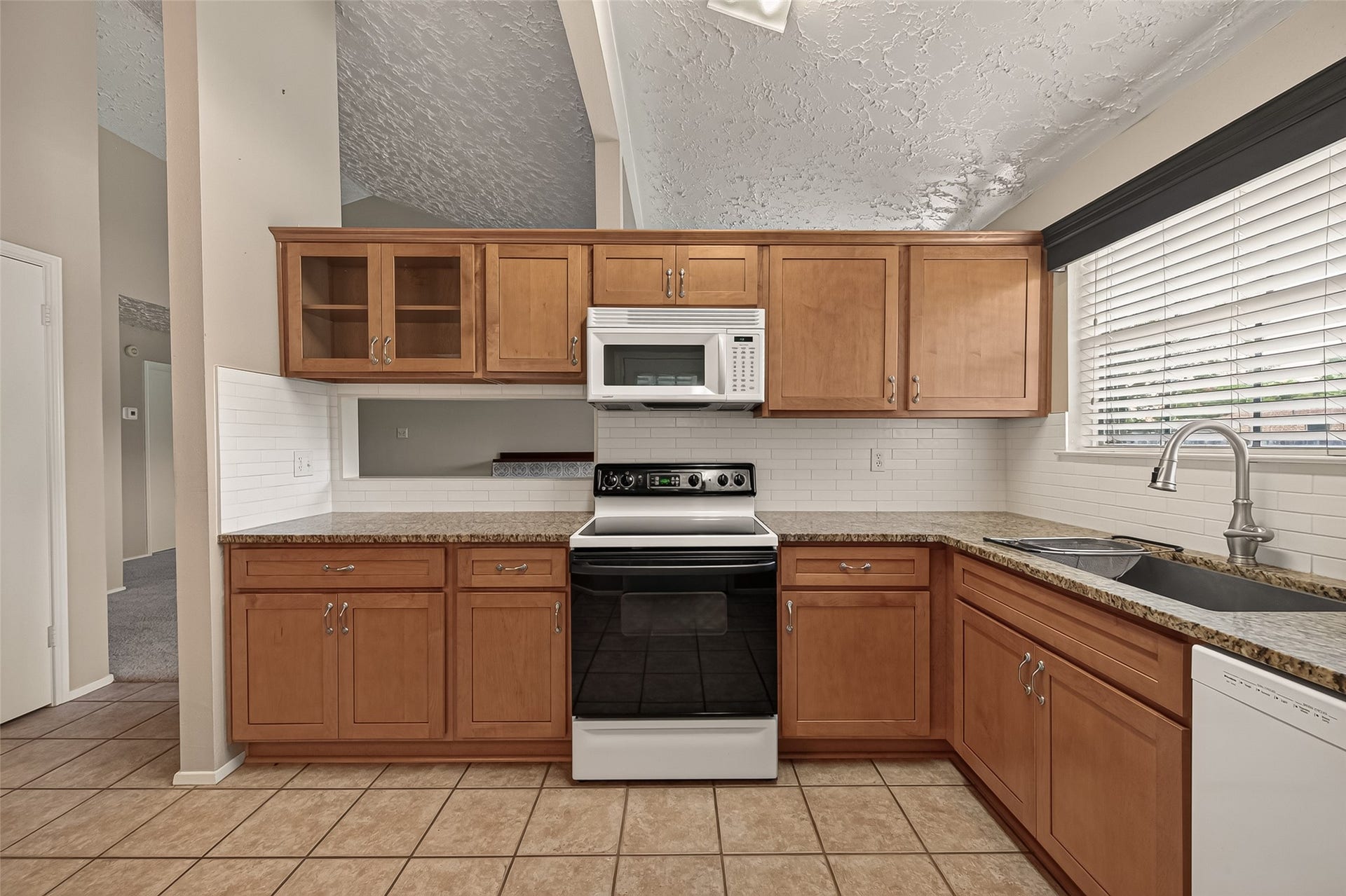2811 Pheasant Creek Drive, Sugar Land, TX 77498 Kitchen features wood cabinetry, range, microwave and convenient workspace.