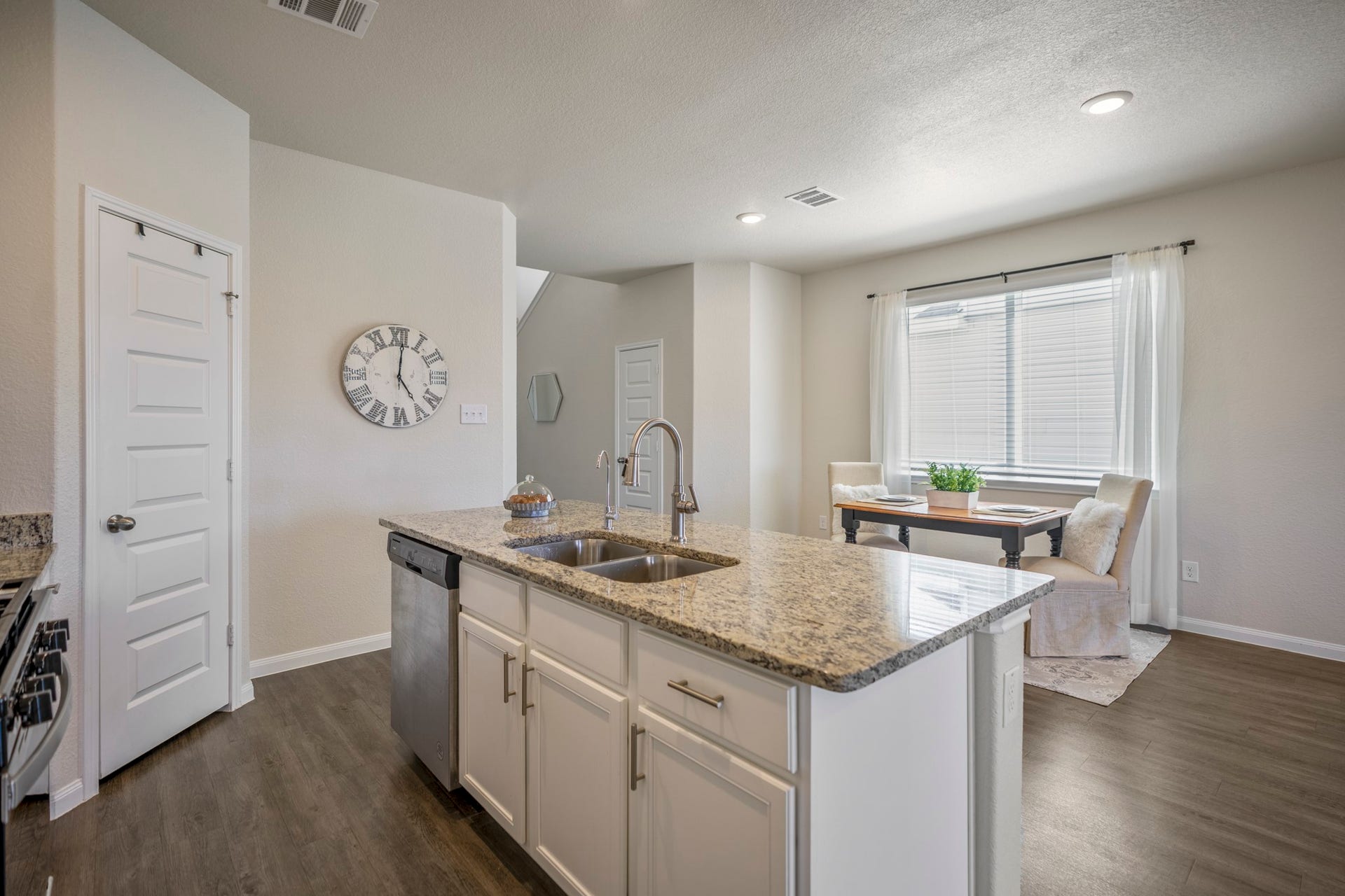 2355 Mount Locke Path, Conroe, TX 77301 Circling back through the kitchen, this angle highlights the granite-topped island and the way it opens toward the dining and living spaces beyond. The sink keeps prep centered in the room, while the surrounding cabinetry, updated hardware and backsplash, stainless appliances, and nearby pantry bring together the practical details that make this space work so well day to day.