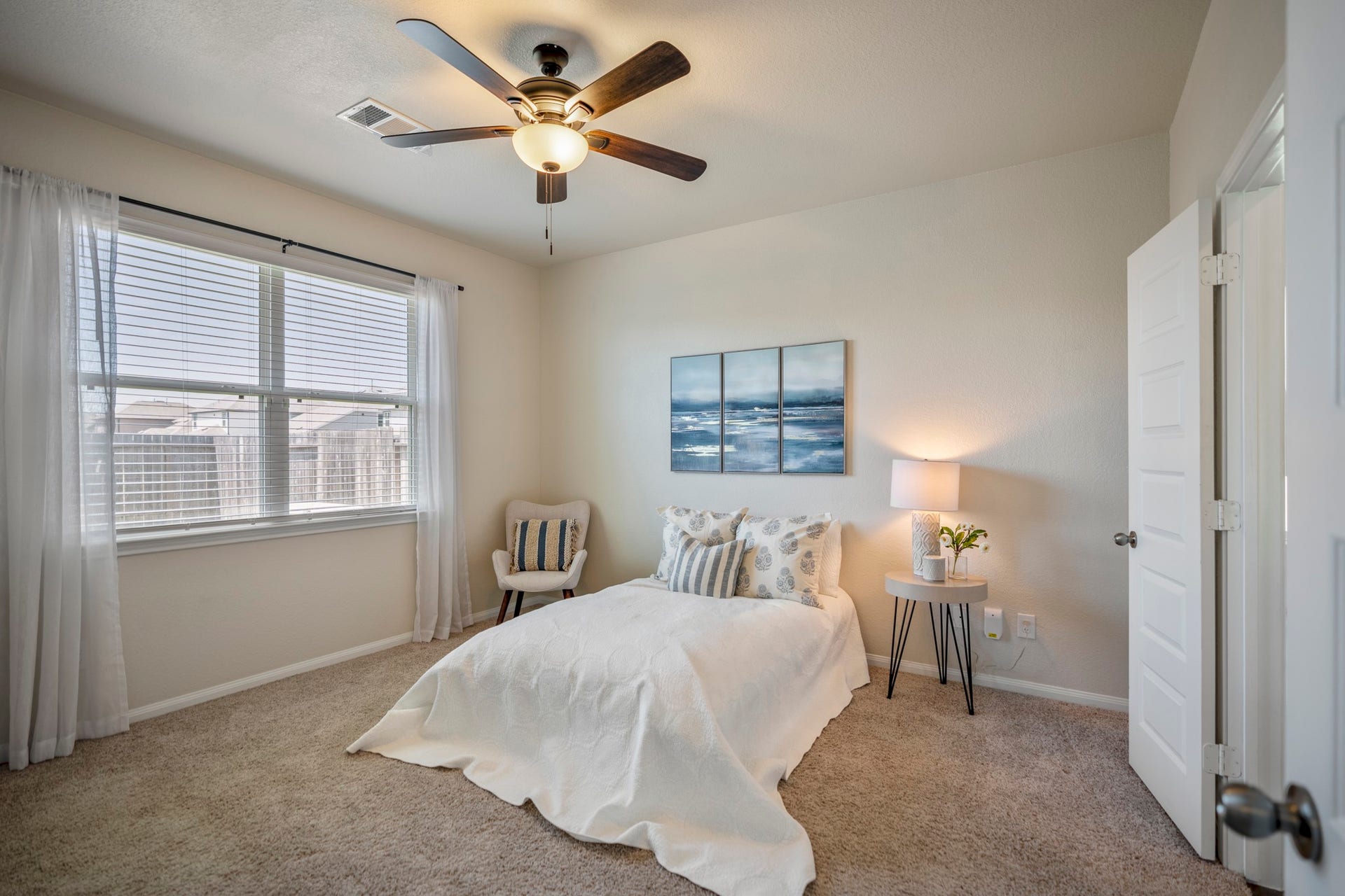 2355 Mount Locke Path, Conroe, TX 77301 Stepping into the first-floor primary suite, two windows bring in natural light while the ceiling fan adds everyday comfort overhead. The doorway on the right leads into the primary bath, with the oversized walk-in closet continuing just beyond.