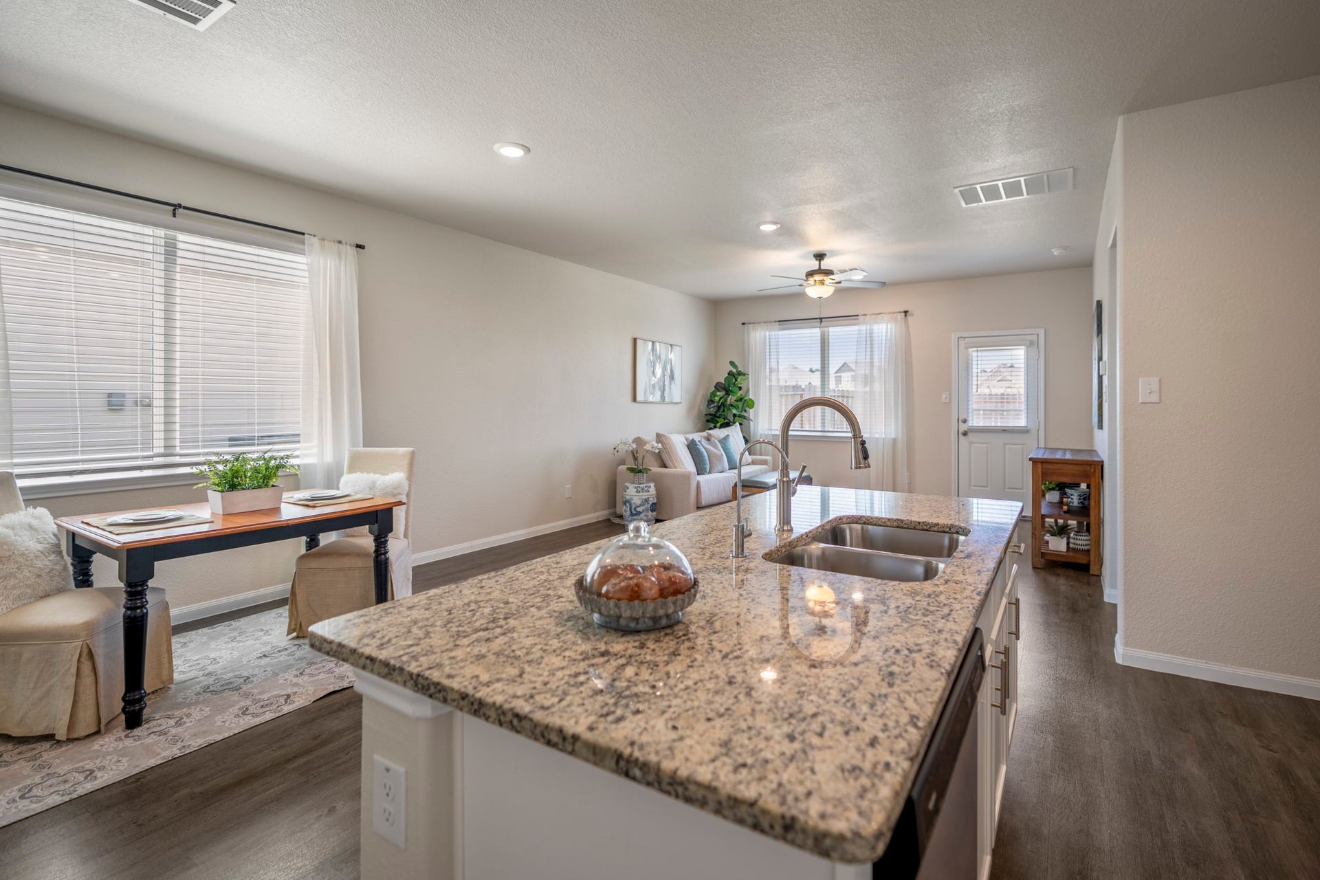 2355 Mount Locke Path, Conroe, TX 77301 Turning back from the kitchen, the island becomes the natural transition into the dining area on the left and the living room ahead. Windows along the dining space and at the back of the home pull in plenty of natural light, while the open layout keeps each area connected without losing its own sense of place.
