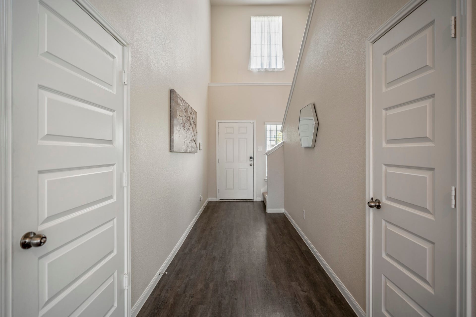 2355 Mount Locke Path, Conroe, TX 77301 Circling back toward the front of the home, this hallway brings us to the staircase and sets up the transition upstairs. The door on the left leads into the attached garage, while the door on the right opens to the half bath. Just ahead, the stairs take us up to the gameroom and three secondary bedrooms.