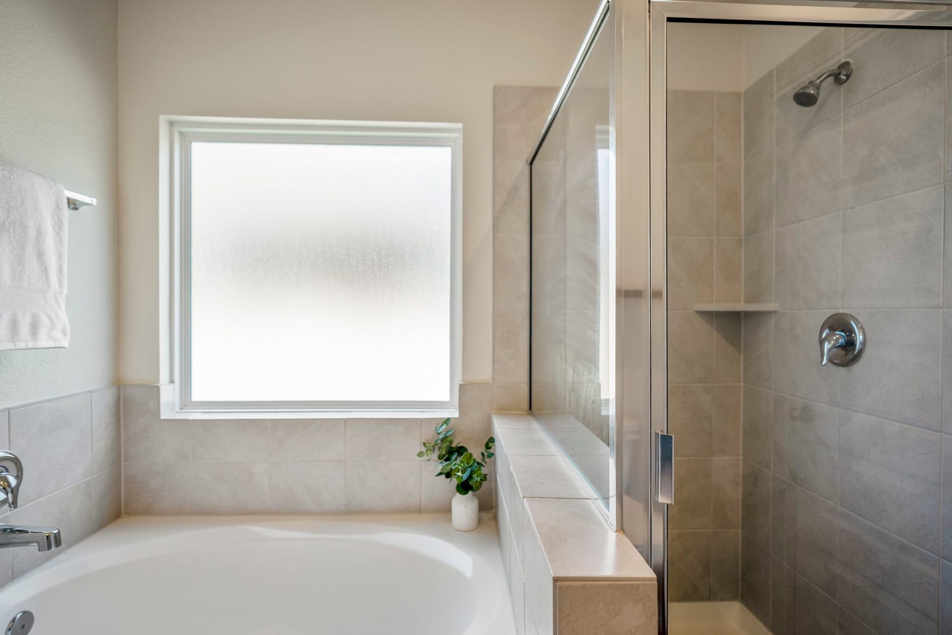 2355 Mount Locke Path, Conroe, TX 77301 Moving deeper into the primary bath, the separate soaking tub sits beneath a frosted window, with the glass-enclosed tile shower just steps away to the right. Built-in shower niches add convenient storage, while the layout keeps both bathing spaces distinct without feeling disconnected.