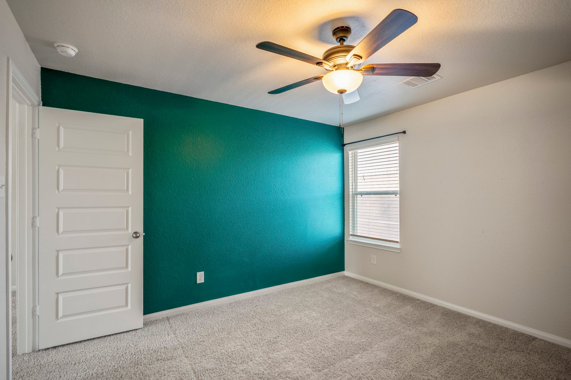 2355 Mount Locke Path, Conroe, TX 77301 Turning within the third bedroom, the bold accent wall adds a pop of personality while the window brings in natural light from the opposite side. The door on the left leads back toward the gameroom, keeping this bedroom just steps from the center of the upstairs living space.