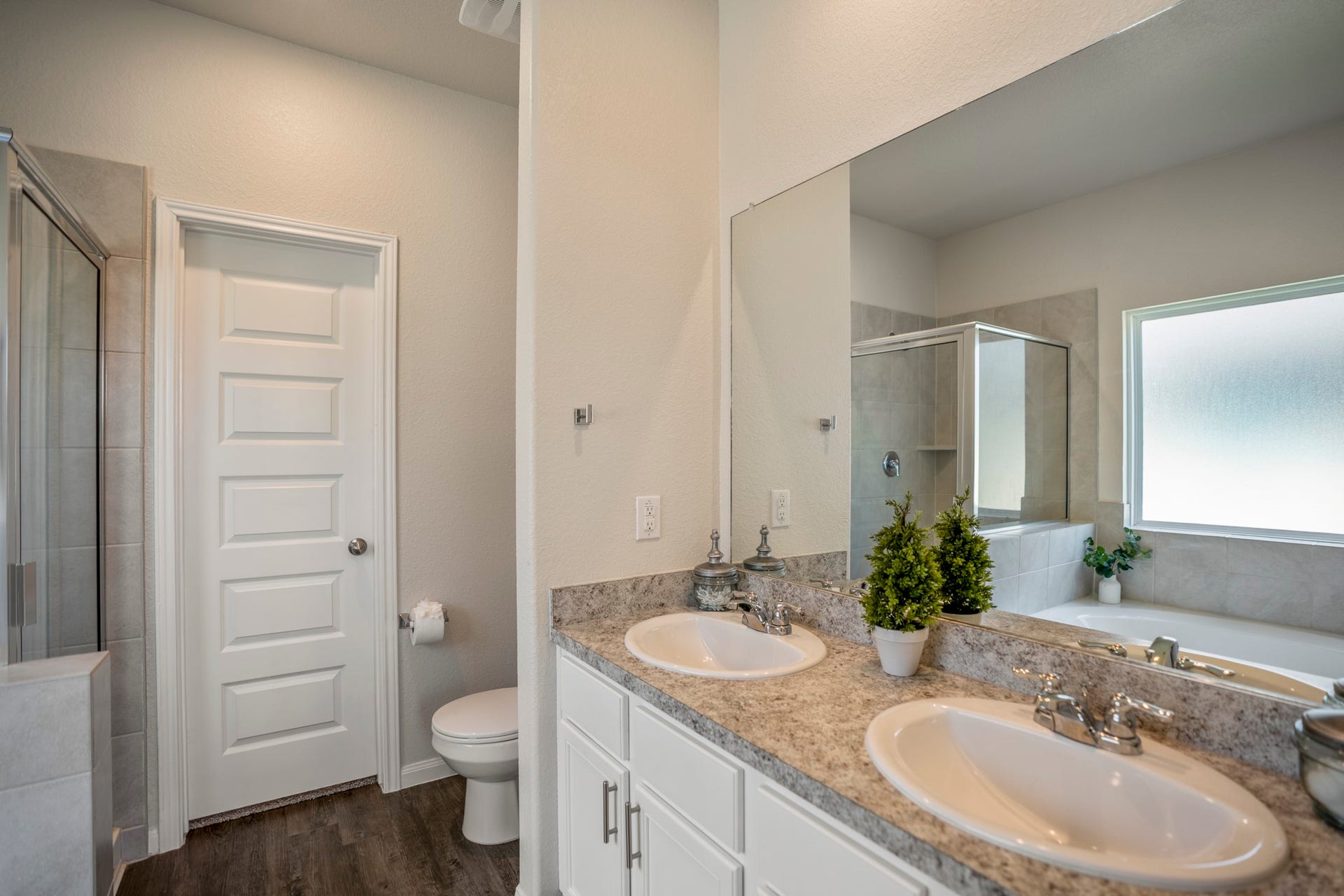 2355 Mount Locke Path, Conroe, TX 77301 Turning toward the vanity, this angle highlights the dual sinks, ample counter space and storage below. Straight ahead, the door opens into the oversized primary walk-in closet, giving the suite an easy flow from bedroom to bath to storage.