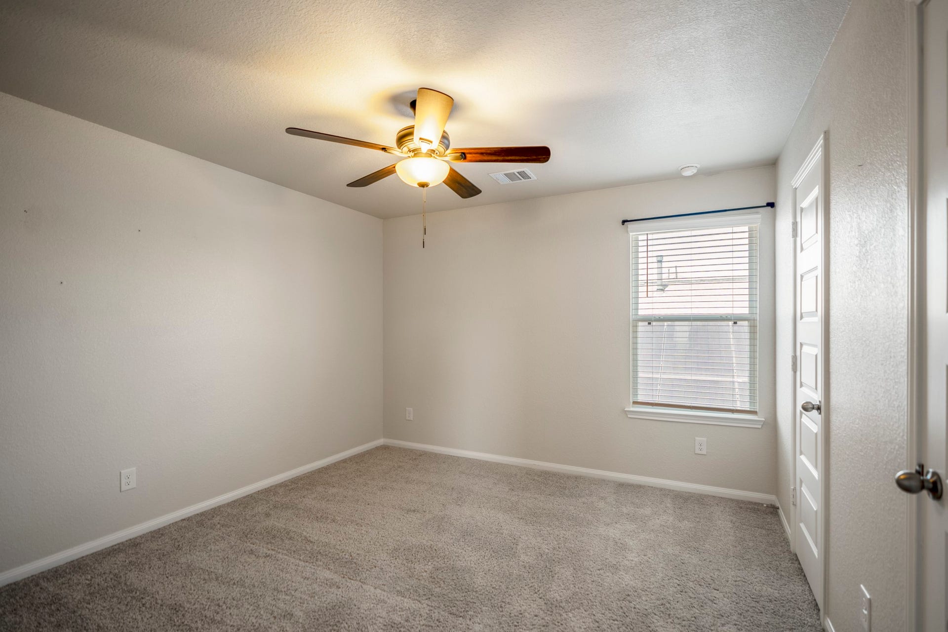 2355 Mount Locke Path, Conroe, TX 77301 Stepping into the fourth bedroom, this upstairs space offers neutral carpeting, a ceiling fan and natural light from the window. Along the right wall, both doors open into the impressively spacious closet, continuing the standout storage found throughout the homes bedrooms.