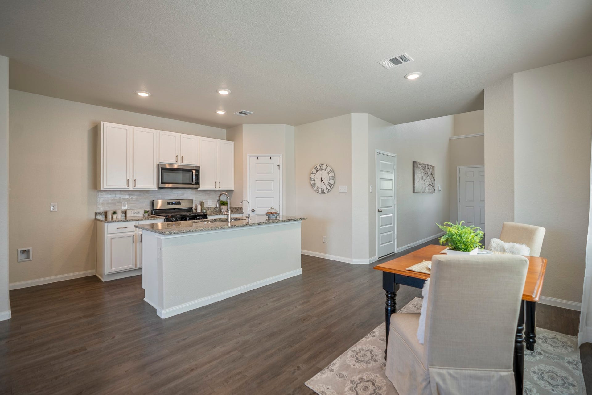 2355 Mount Locke Path, Conroe, TX 77301 Circling back at the dining area gives a wider look at how naturally it connects with the kitchen. The island stretches across the center for prep and casual seating, while the cabinetry, stainless appliances and updated backsplash line the far wall. The pantry is tucked beyond the kitchen to the right, keeping storage close at hand without interrupting the open flow of the space.