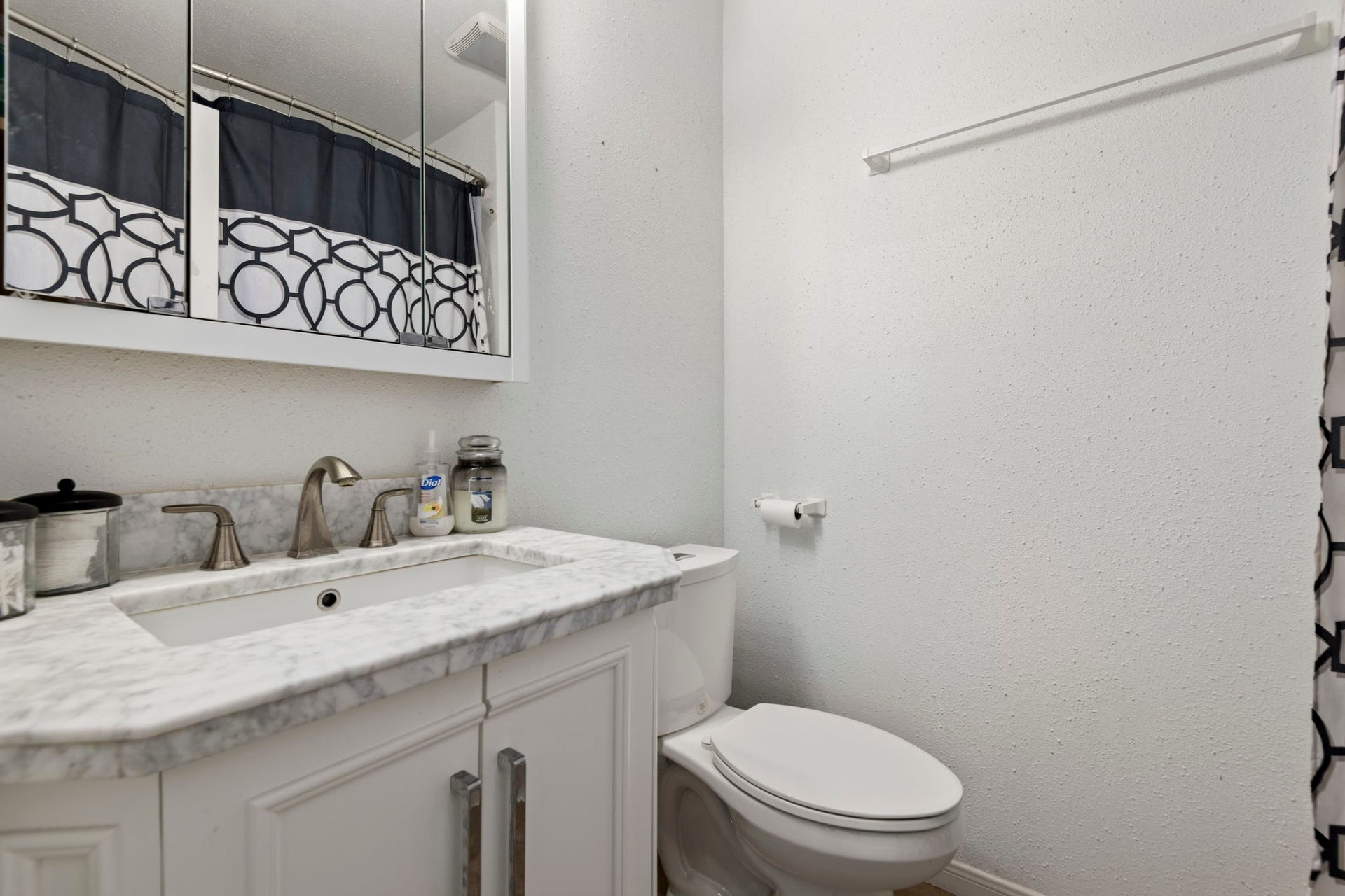 The ensuite bathroom attached to bedroom 1 has a shower/tub combo and charming vanity.