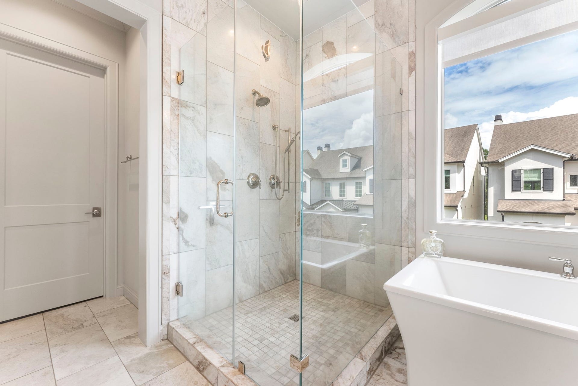 10 Nautical Terrace Way, The Woodlands, TX 77380 Oversized frameless shower with fixed and handheld showerheads beside a deep soaking tub, designed for both quick mornings and slow evenings.