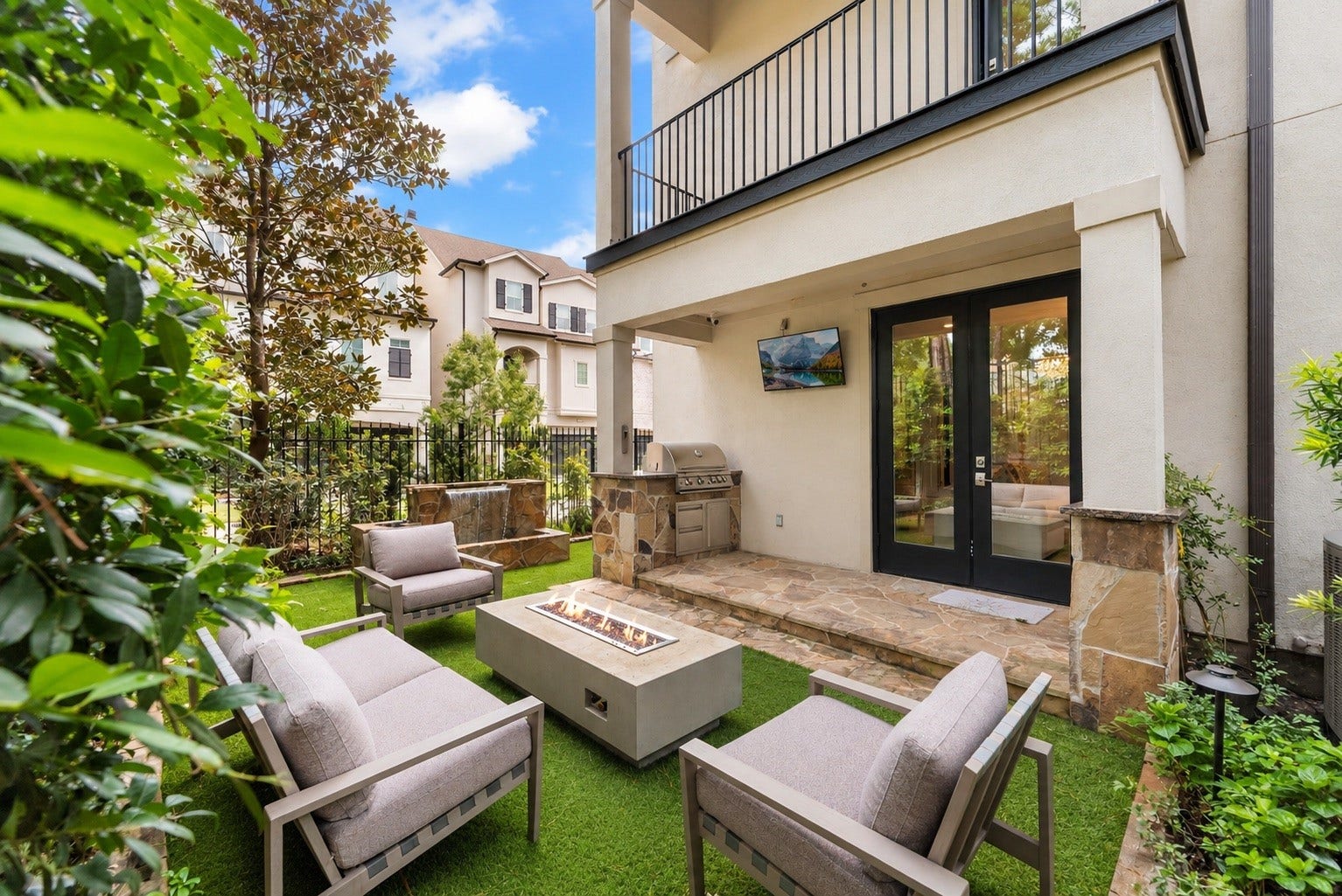 10 Nautical Terrace Way, The Woodlands, TX 77380 Turnkey outdoor kitchen with built-in grill, gas firepit and weatherproof television, steps from the first-floor flex suite for effortless entertaining.