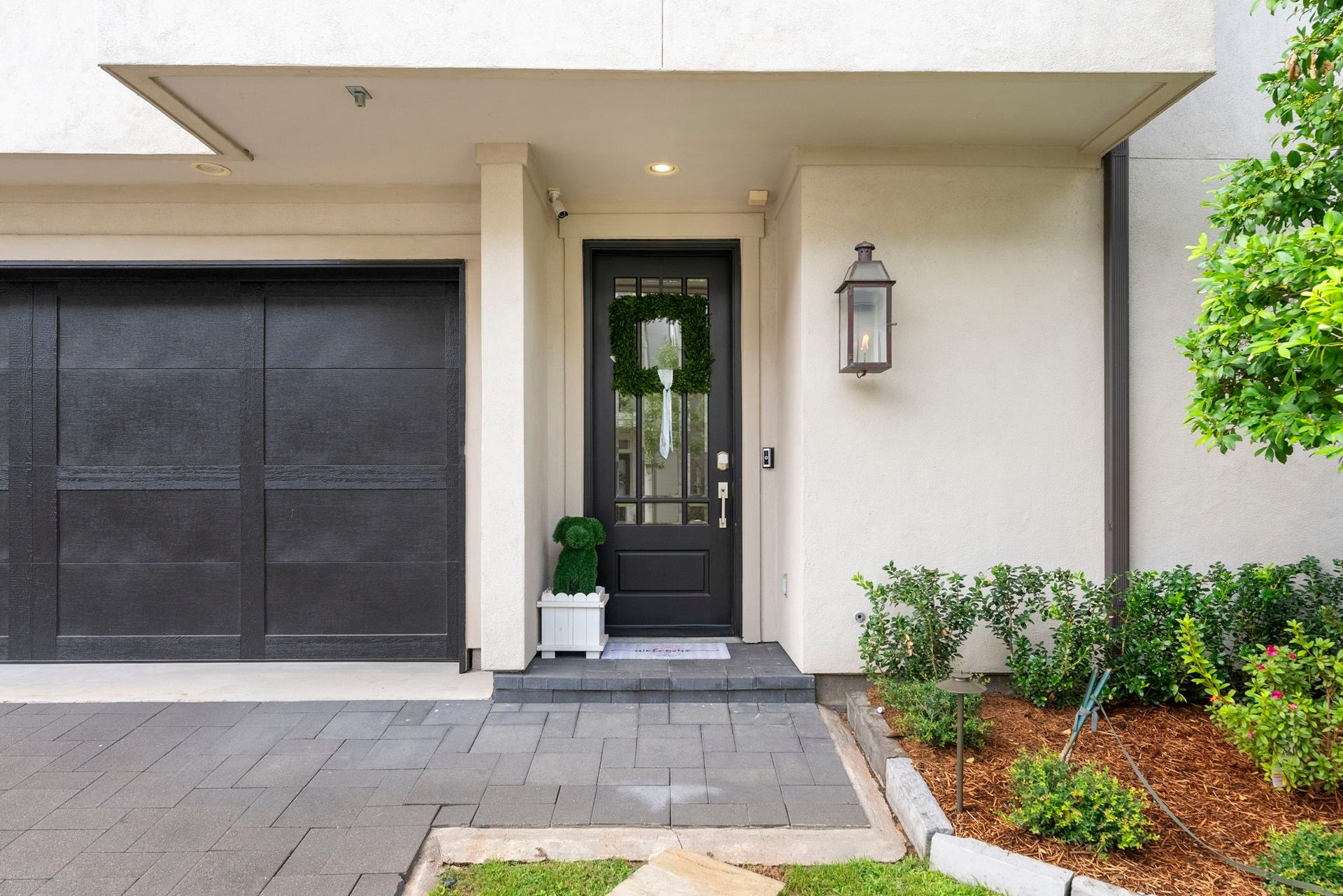 10 Nautical Terrace Way, The Woodlands, TX 77380 Welcoming covered entry with a glass-paneled front door, flickering copper gas lantern, keyless smart lock, video doorbell and security camera for added peace of mind, framed by landscape lighting and tidy plantings.
