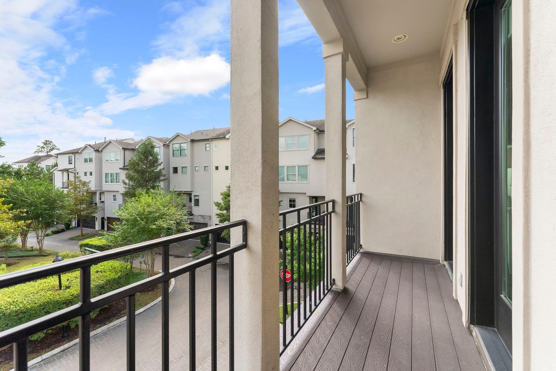 10 Nautical Terrace Way, The Woodlands, TX 77380 Private covered balcony off the primary suite with durable composite flooring and overhead lighting, an inviting spot for morning coffee overlooking the gated community's manicured grounds.
