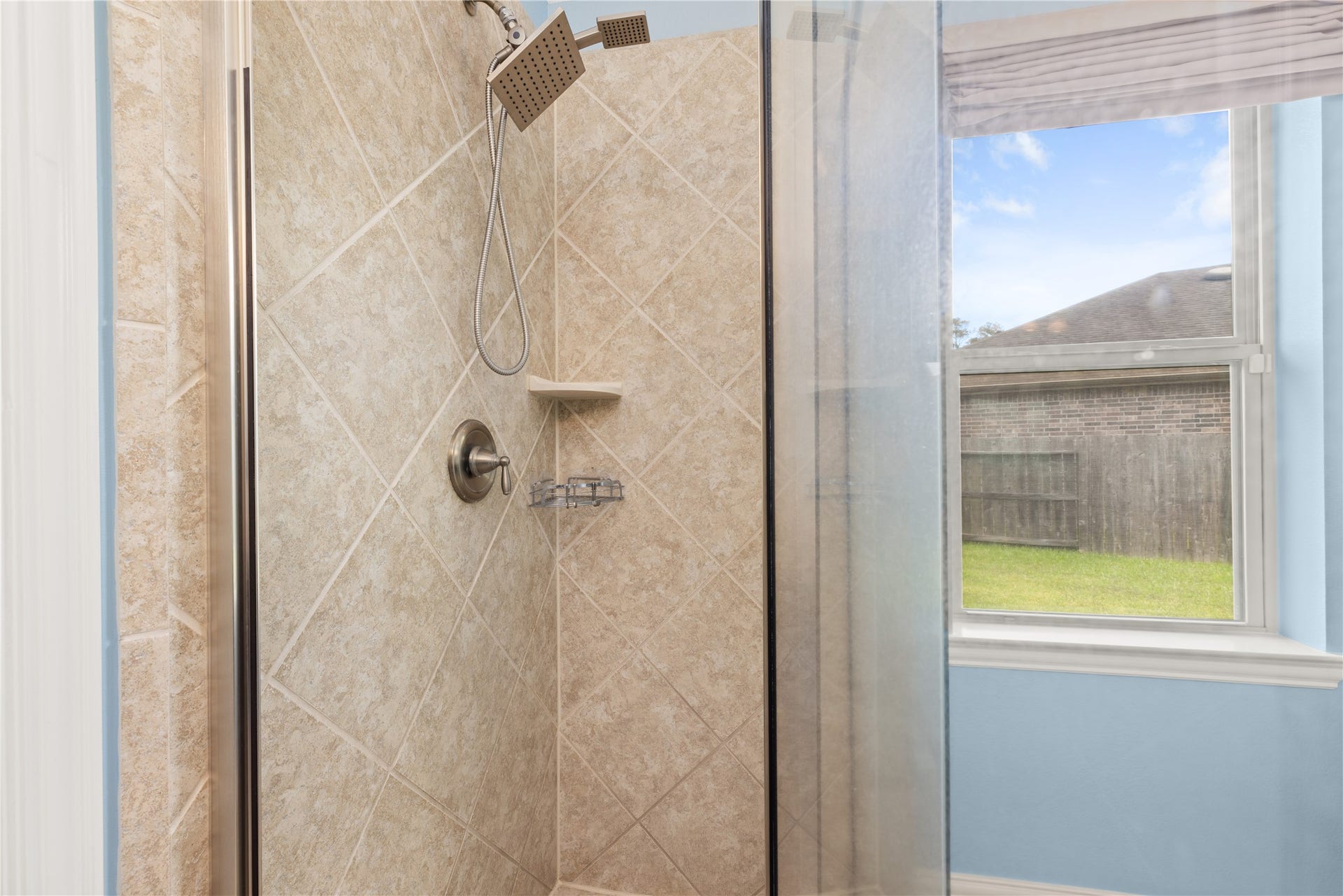 20507 Emery Manor Lane, Porter, TX 77365 Elegant shower with modern fixtures and natural light from a nearby window, offering a serene bathing experience.