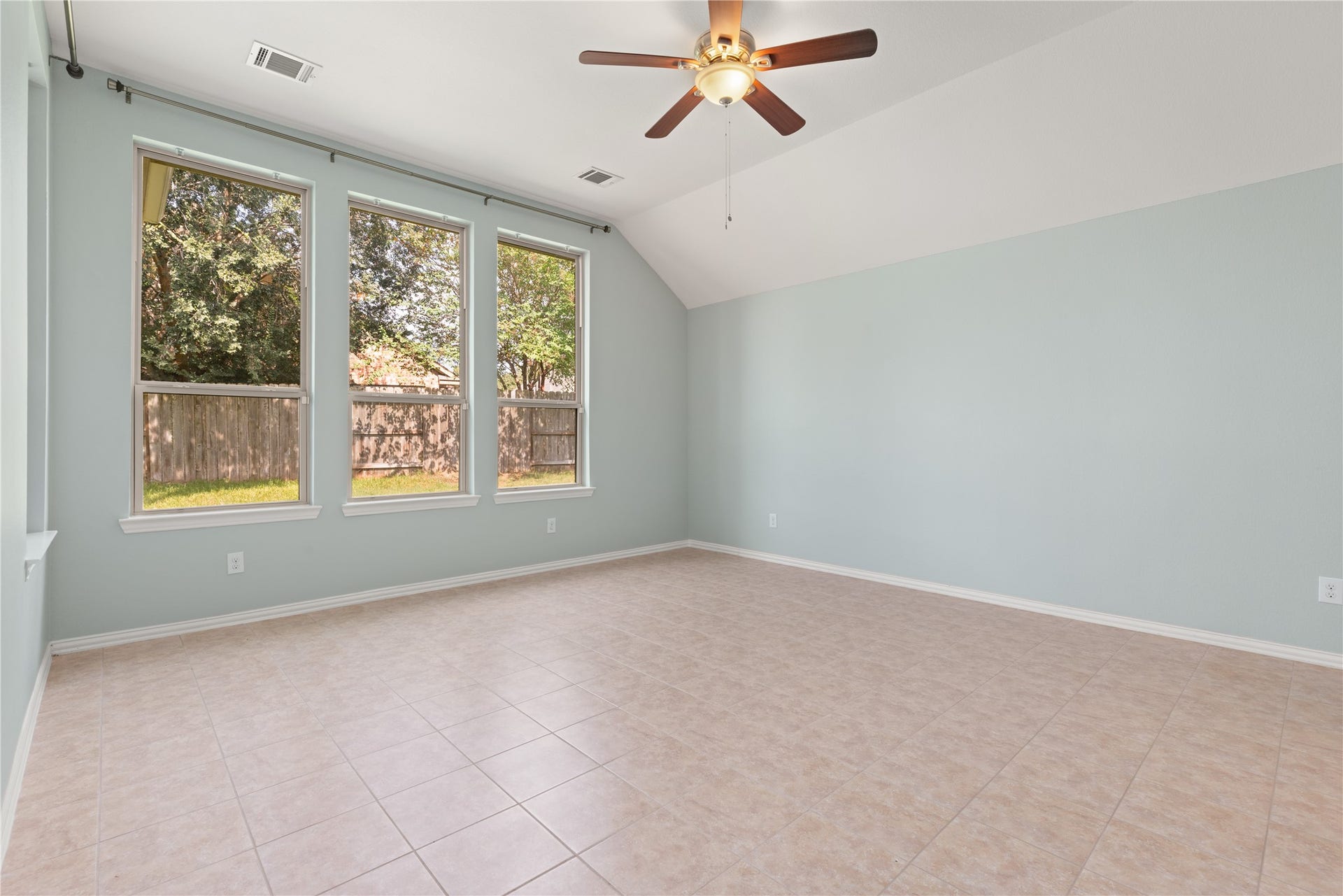 20507 Emery Manor Lane, Porter, TX 77365 Spacious room with elegant tile flooring, abundant natural light from large windows, and a ceiling fan for comfort.