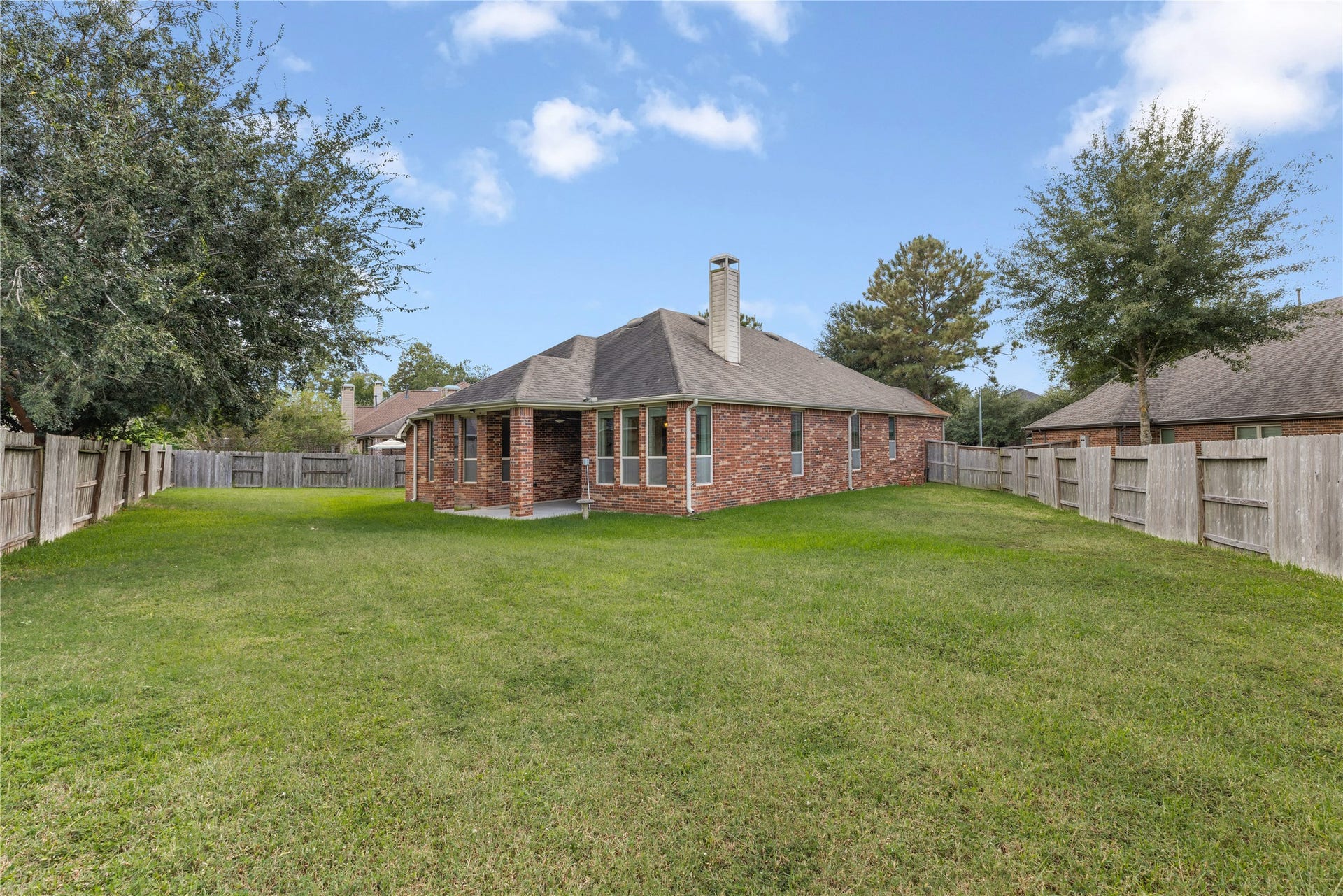 20507 Emery Manor Lane, Porter, TX 77365 Spacious backyard with well-maintained lawn, surrounded by a wooden fence, offering privacy and ample space for outdoor activities.
