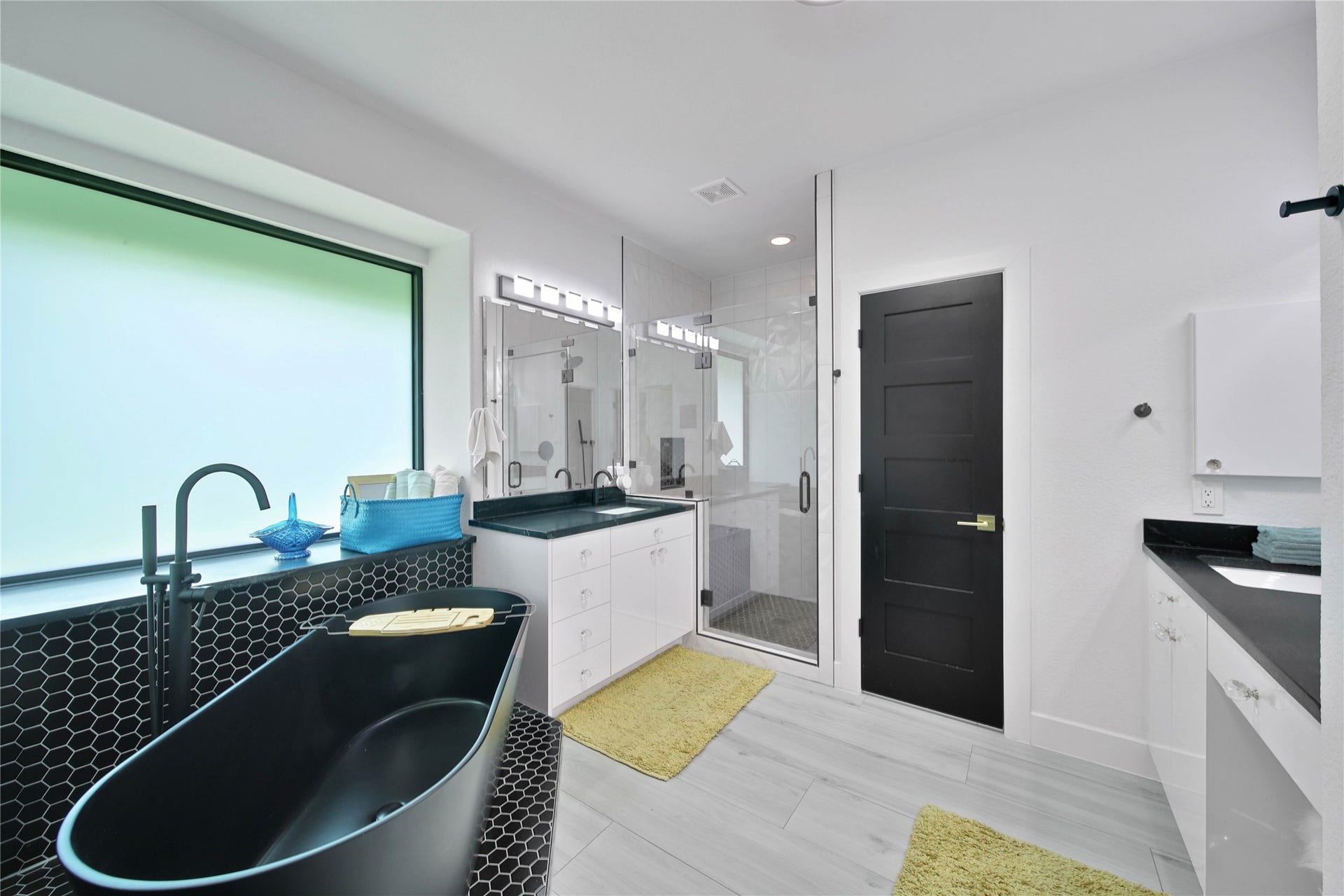 142 Pronghorn Place, Montgomery, TX 77316 Primary Bathroom. Sleek black freestanding tub, glass-enclosed shower, and dual vanities with seating at one.