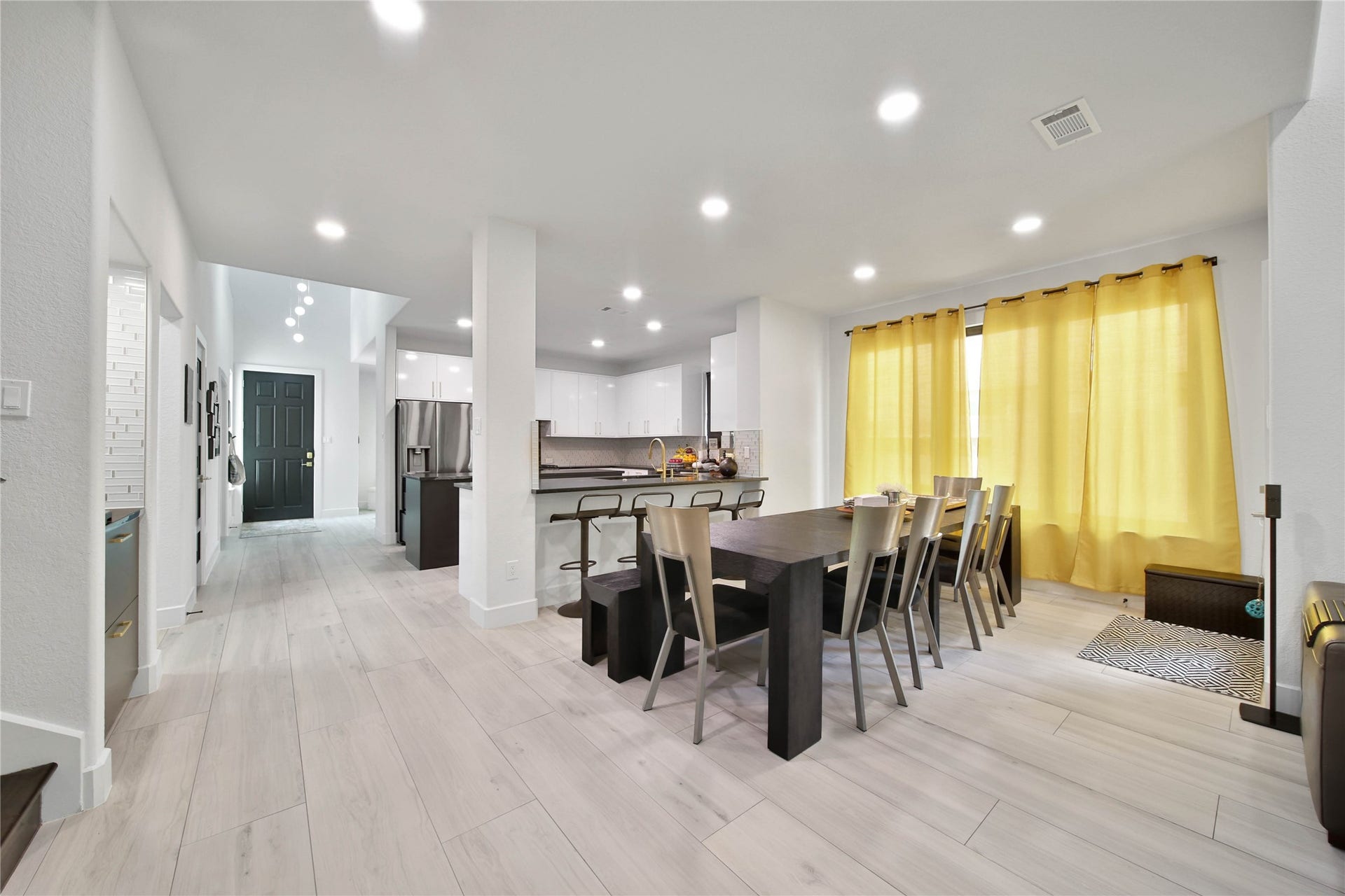 142 Pronghorn Place, Montgomery, TX 77316 Open-concept breakfast/dining and kitchen area with sleek light glooring and recessed lighting. Breakfast bar currently holds 4 stools. Breakfast area has room for a 10-foot table, shown.