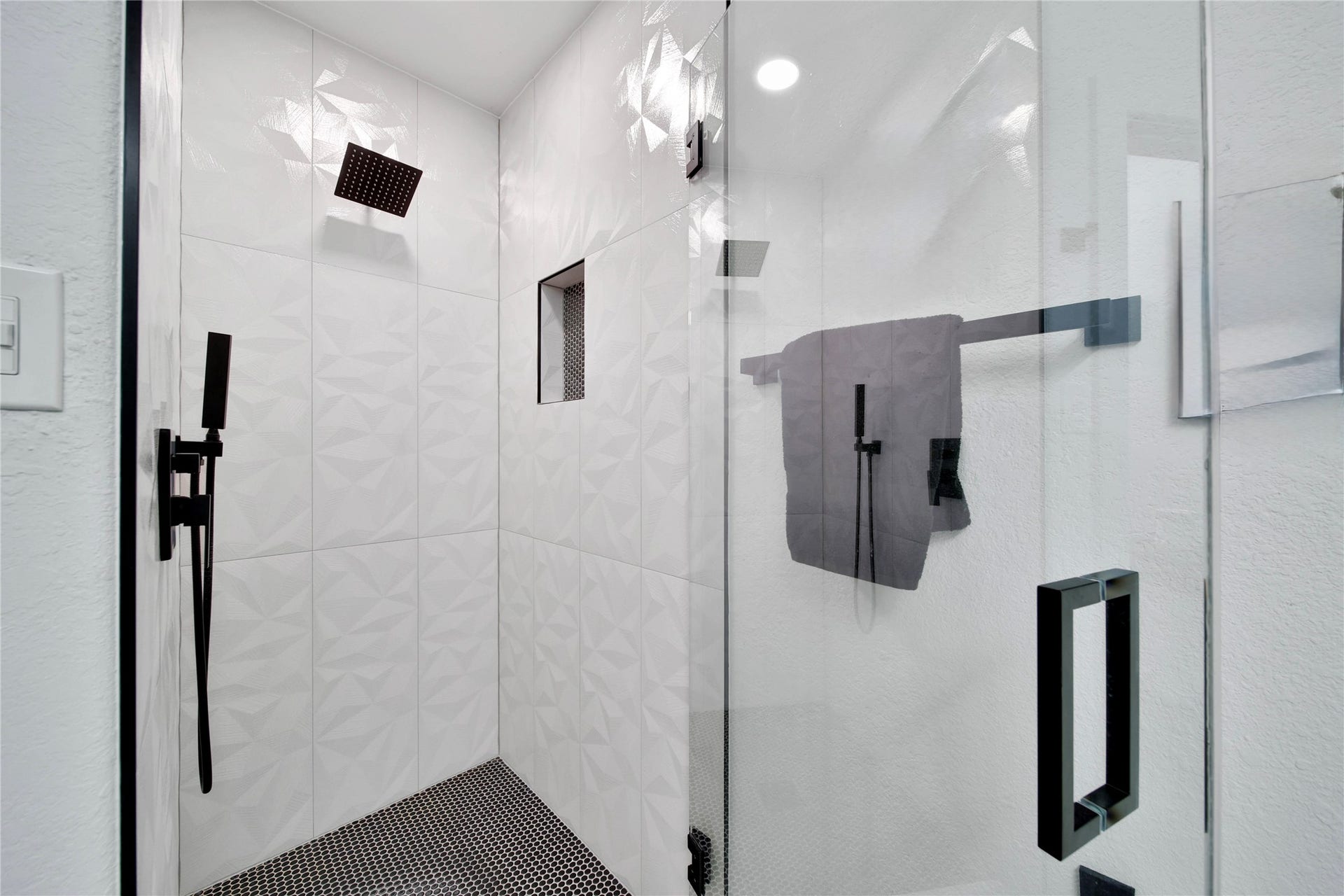 142 Pronghorn Place, Montgomery, TX 77316 Downstairs bathroom accessible from hallway and secondary downstairs bedroom. Features a sleek glass-enclosed shower with rainfall shower head and wand.