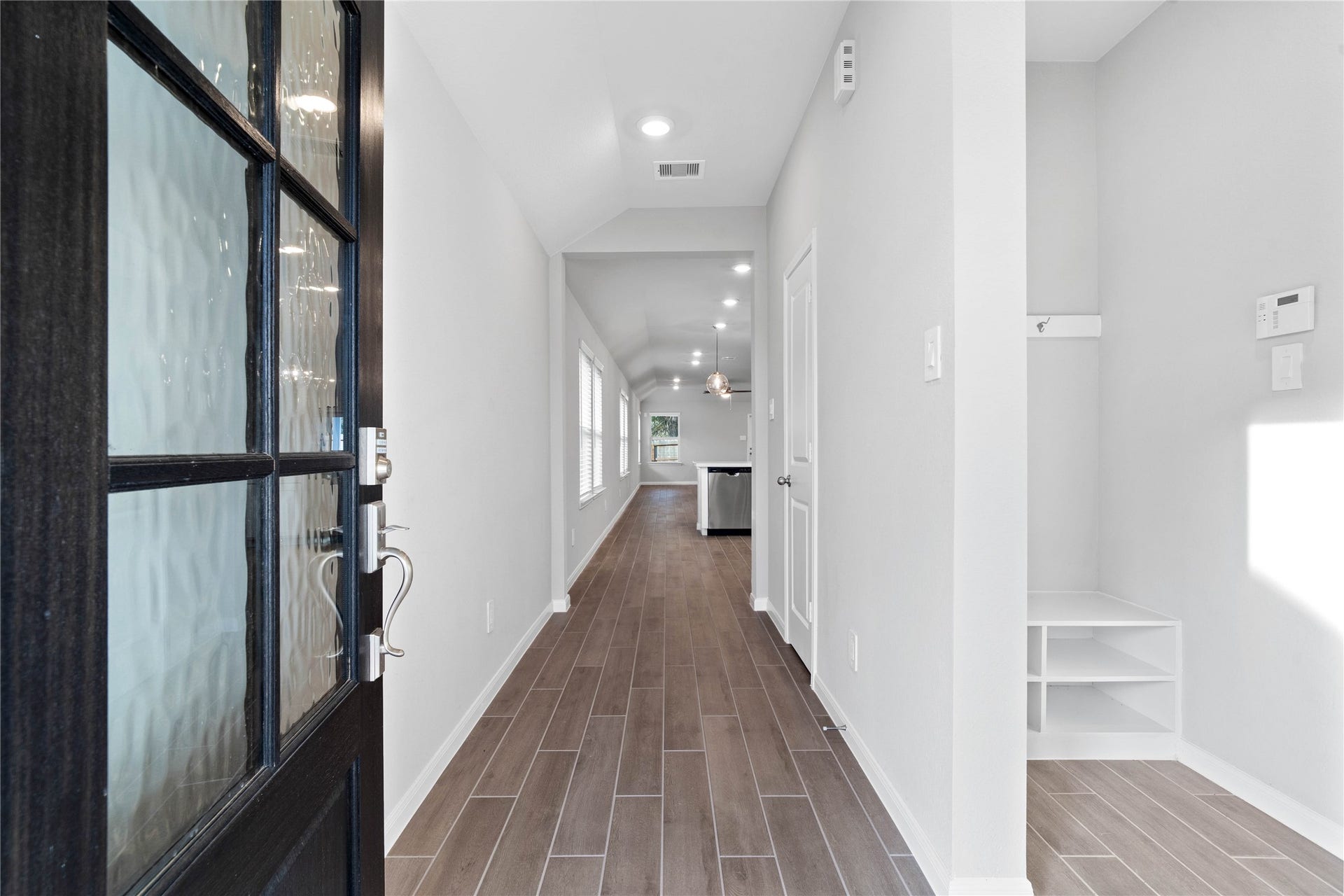 19560 Stripe Hill Bend, Montgomery, TX 77316 This entryway features a modern, open-concept design. The long, bright corridor utilizes a neutral color palette, recessed lighting, and floor tiles to lead the eye toward the home's main living area.