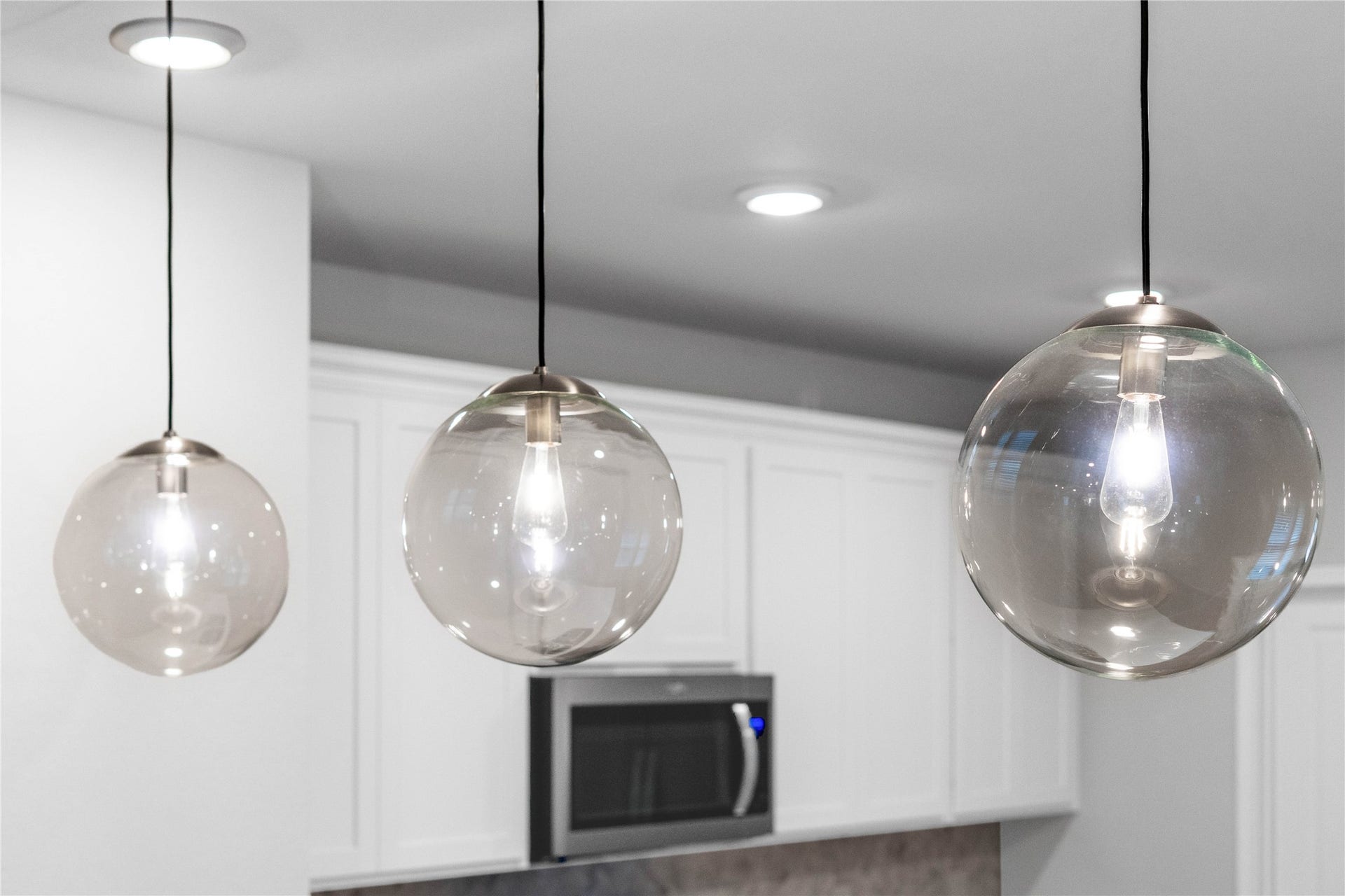 19560 Stripe Hill Bend, Montgomery, TX 77316 Atwell Pendant Brushed Nickel lights that hang over the kitchen counter.