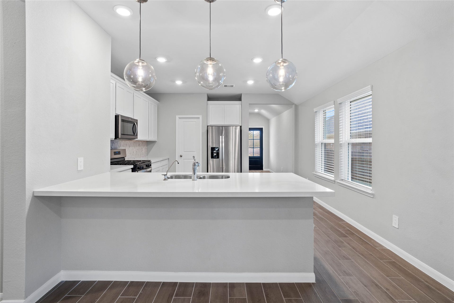 19560 Stripe Hill Bend, Montgomery, TX 77316 The expansive quartz-topped counter stands as the home's true heartbeat, offering a natural gathering spot where family and friends naturally gravitate to share meals, conversation, and connection.