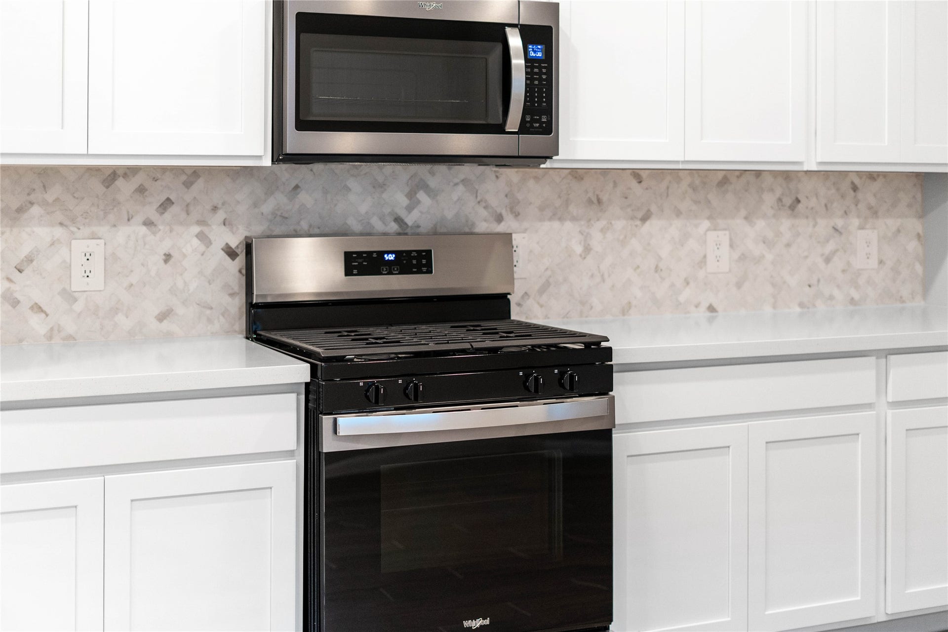 19560 Stripe Hill Bend, Montgomery, TX 77316 Showcased here is a Whirlpool gas range featuring a versatile center oval burner, paired with a steam microwave equipped with sensor cookingall framed by the elegant tile backsplash.