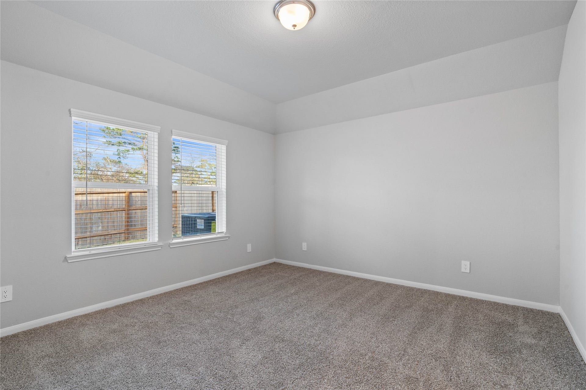 19560 Stripe Hill Bend, Montgomery, TX 77316 The primary bedroom provides a peaceful escape with a bright, neutral palette, sloped ceilings, large windows, and plush carpet flooring, creating a calm and restorative atmosphere to end your day.
