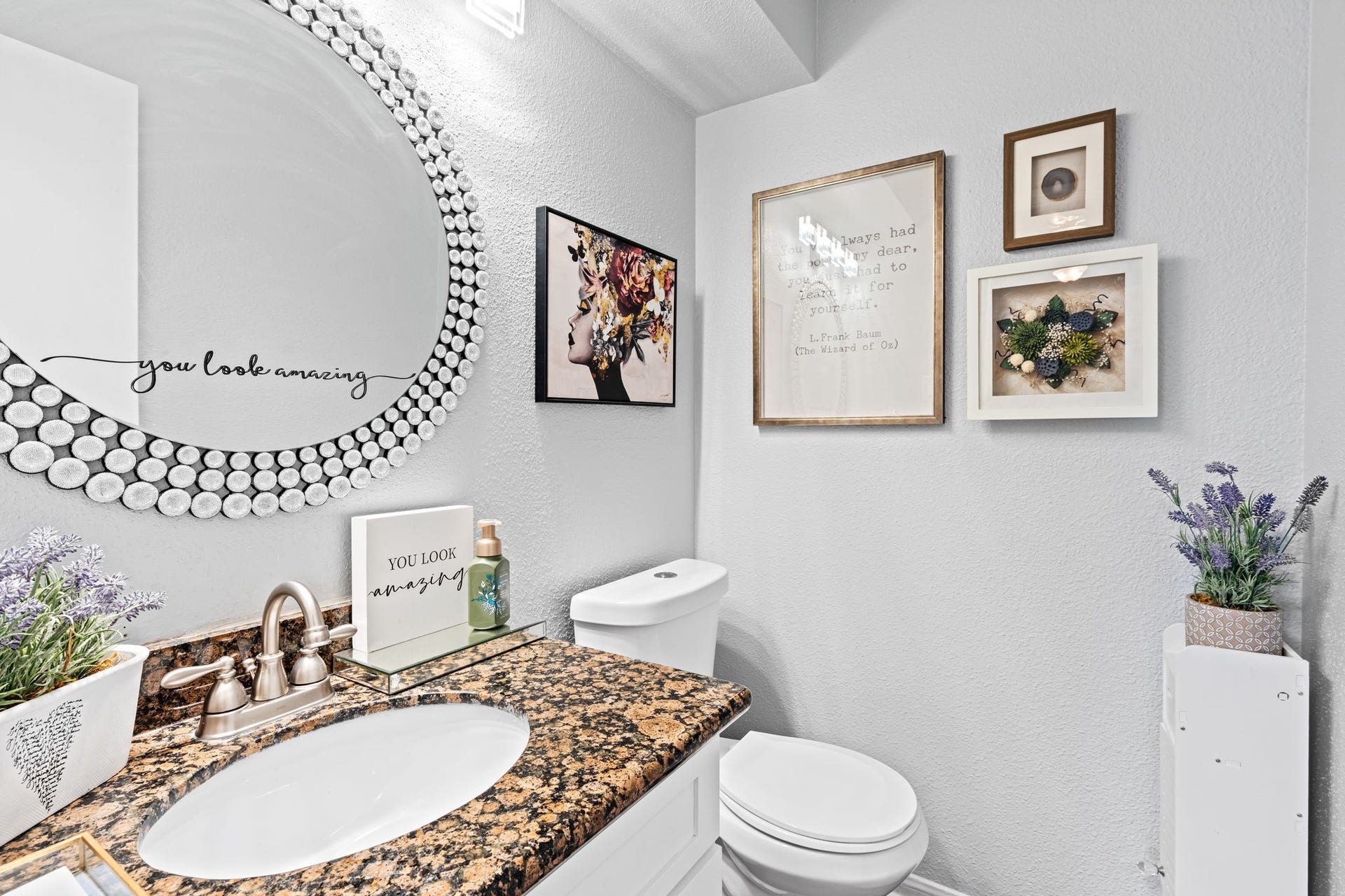 2211 S Kirkwood Road, #1, Houston, TX 77077 The powder bath makes no attempt to blend in an oversized round mirror with a crystal bubble frame fills most of the wall above a dark speckled granite vanity, turning a half bath typically treated as an afterthought into one of the more distinctive rooms on the first floor.