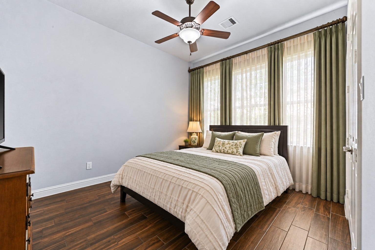 The private Guest Suite is thoughtfully tucked away, offering wonderful comfort and privacy! Featuring impressive high ceilings, a ceiling fan & spacious walk-in closet, this inviting retreat is perfect for overnight guests or extended family. Photo is Virtually Staged.