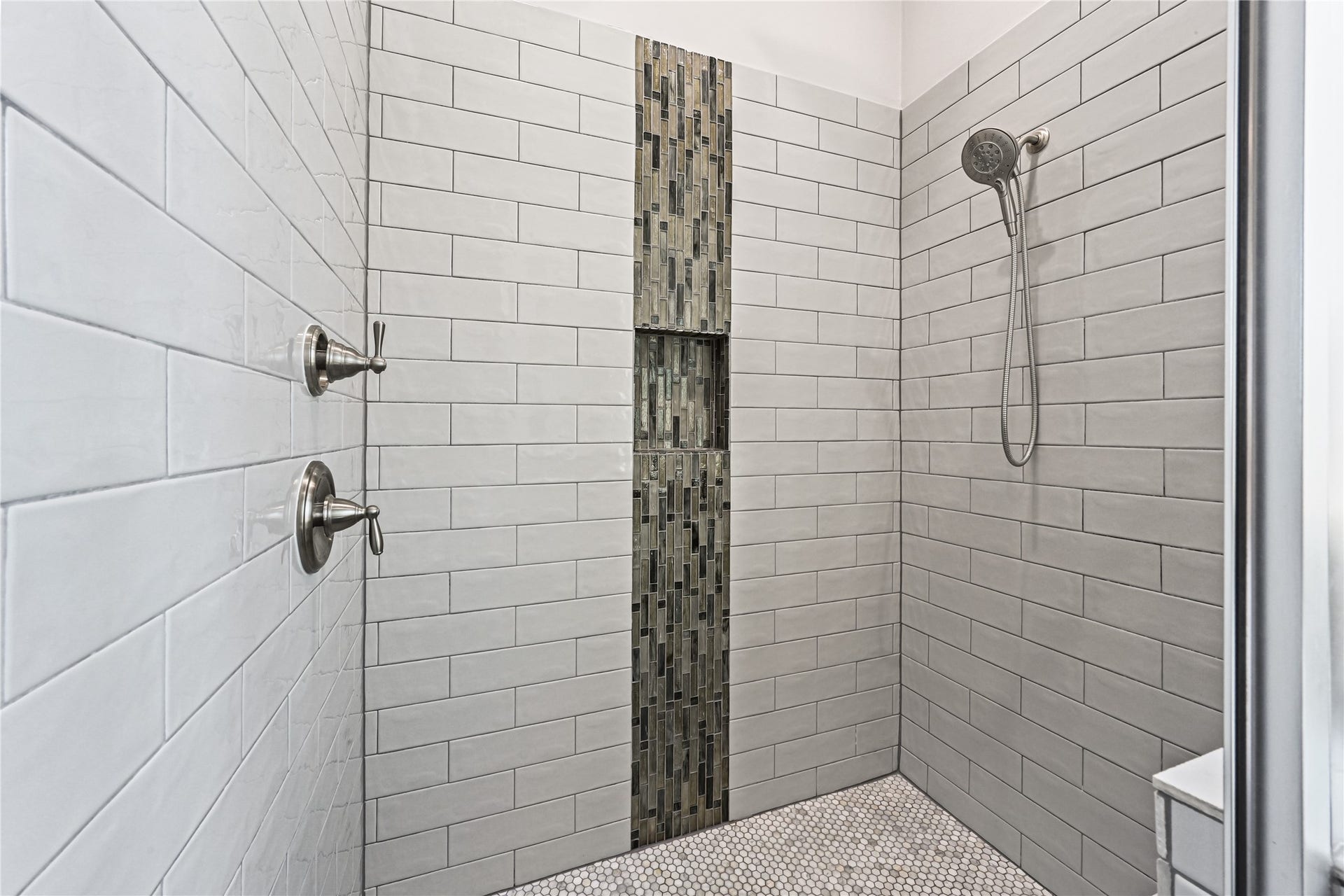 WOW! Step into this massive walk-in shower beautifully finished with custom designer tile from top to bottom and gorgeous coordinating tile flooring. Spacious, luxurious & thoughtfully designed, this impressive shower completes the spa-like feel of your private primary bathroomsimply stunning!