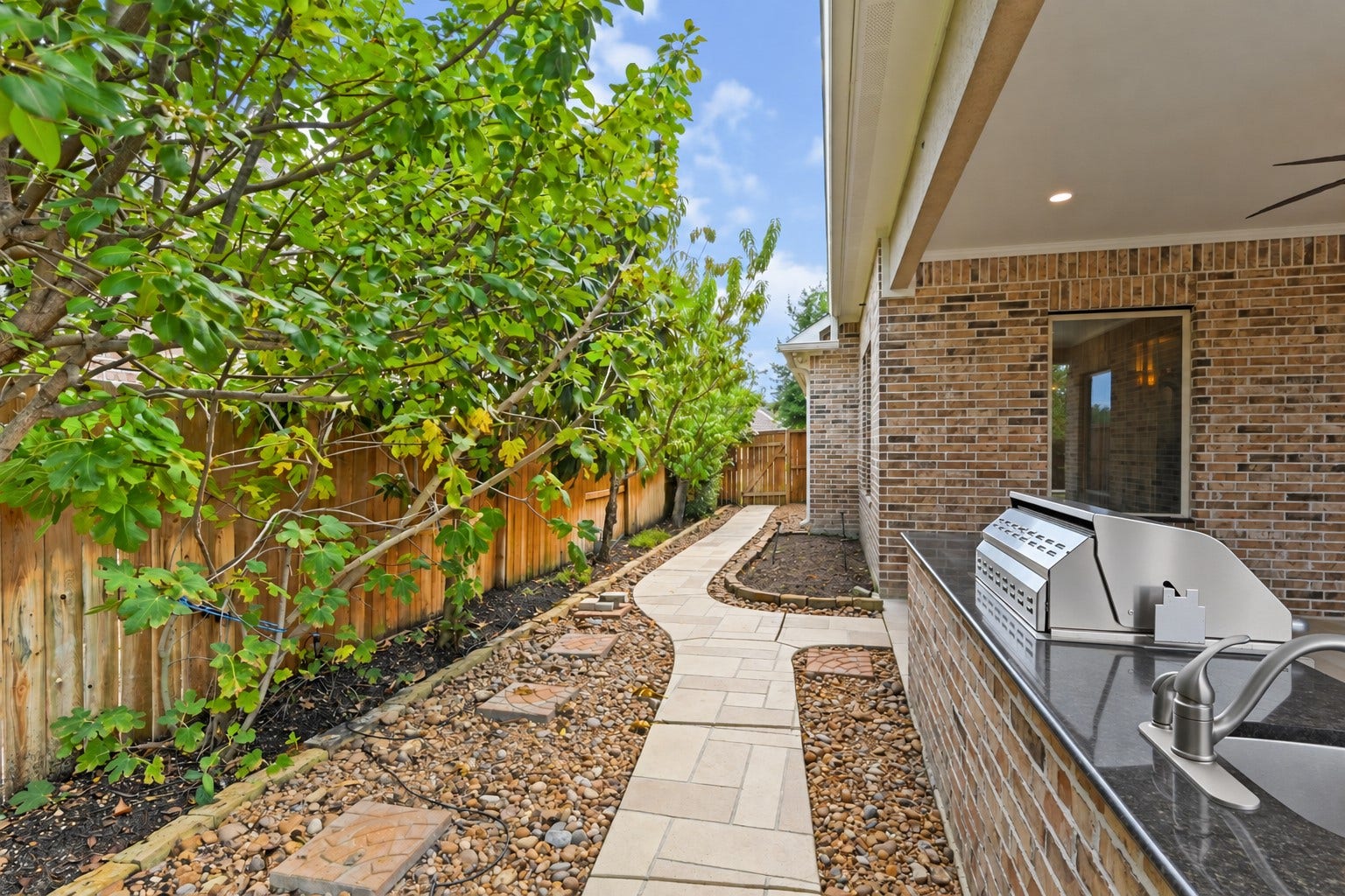 Stroll along the beautiful custom walkway accented with gorgeous travertine tile and surrounded by lush landscaping & fruit trees! Every detail of this private backyard retreat was thoughtfully designed to create a peaceful, inviting outdoor escape. Simply beautiful!
