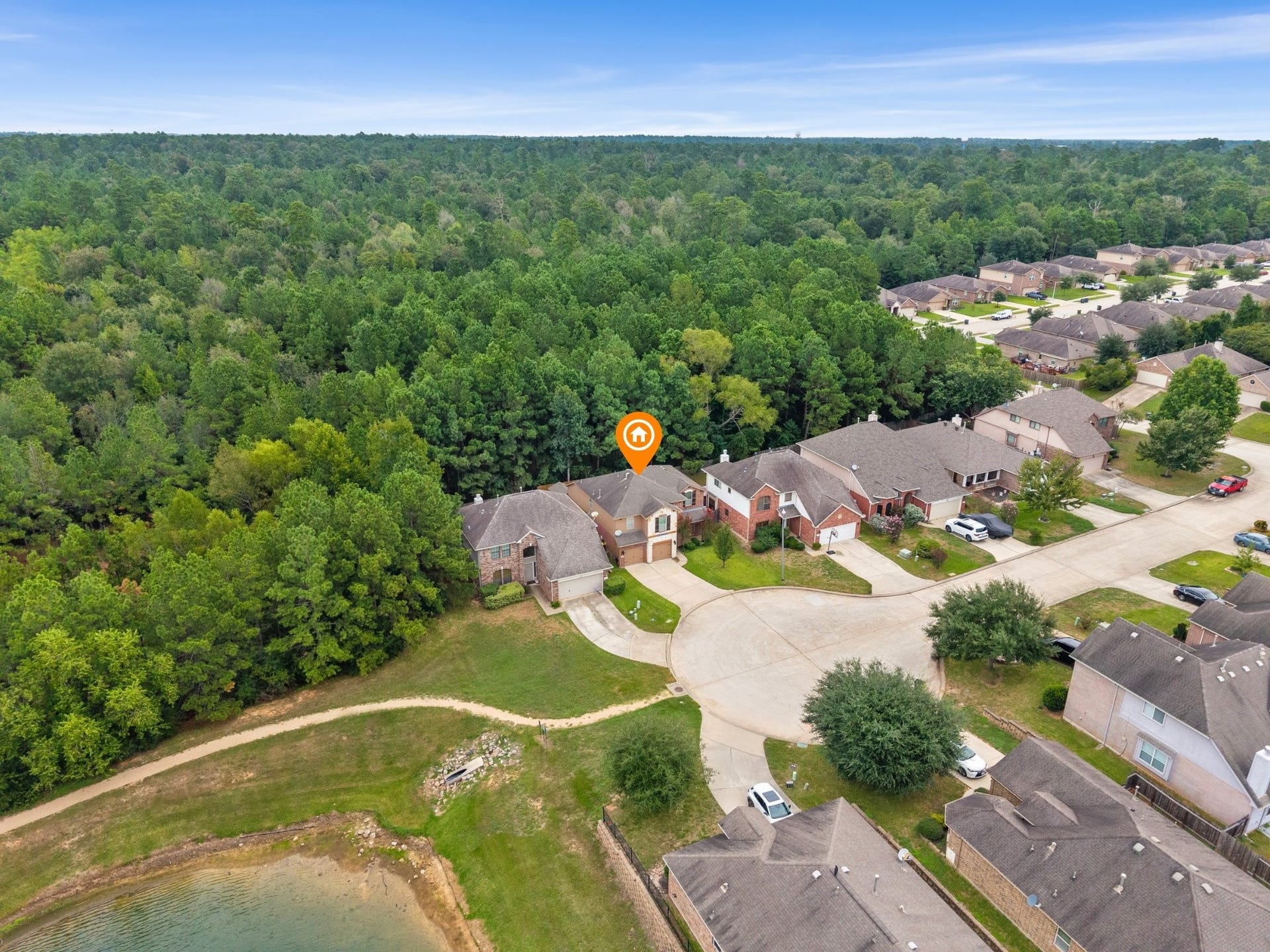 Wide aerial view illustrating the homes prime cul-de-sac location, backed directly by an expansive forest preserve and located adjacent to a peaceful community pond and walking trail.