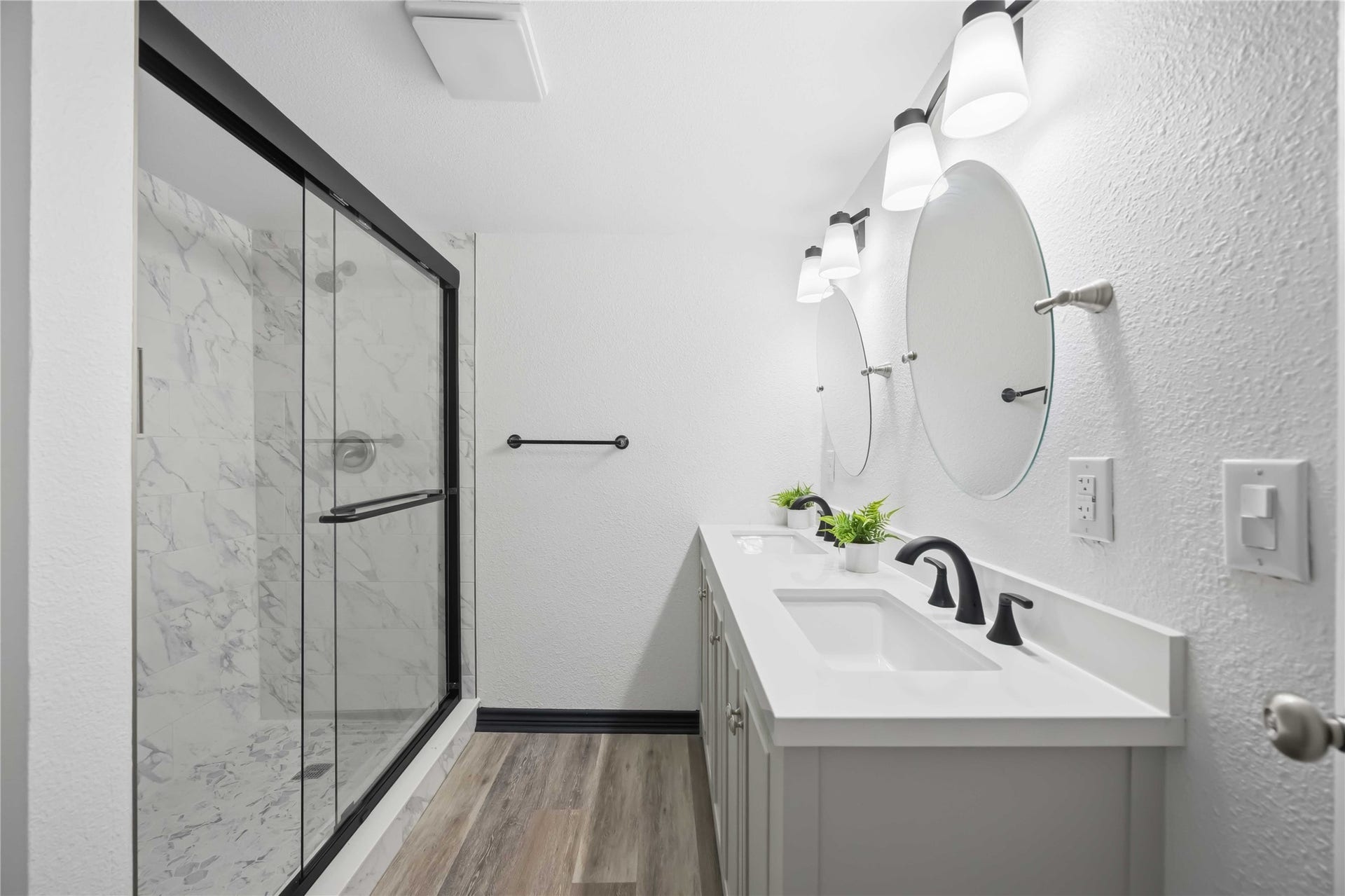 9723 Oldcrest Drive, Stafford, TX 77477 Primary bath with two sinks and vanities and a large stand-up shower.