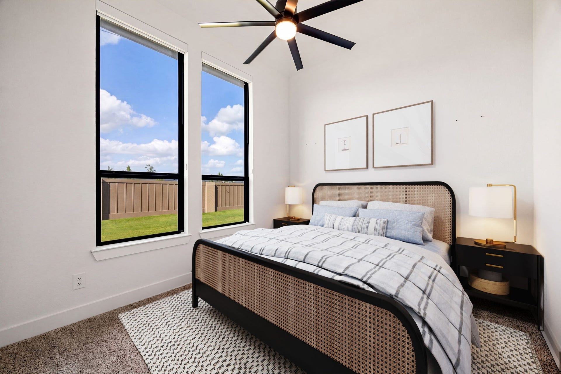 31322 Crescent Hill Drive, Fulshear, TX 77441 A bright and inviting guest retreat. Two tall, black-trimmed vertical windows with pull down black out shades pull in abundant natural light, beautifully accentuating the home's high-end wide-plank flooring, crisp neutral walls, and modern multi-blade ceiling fan.