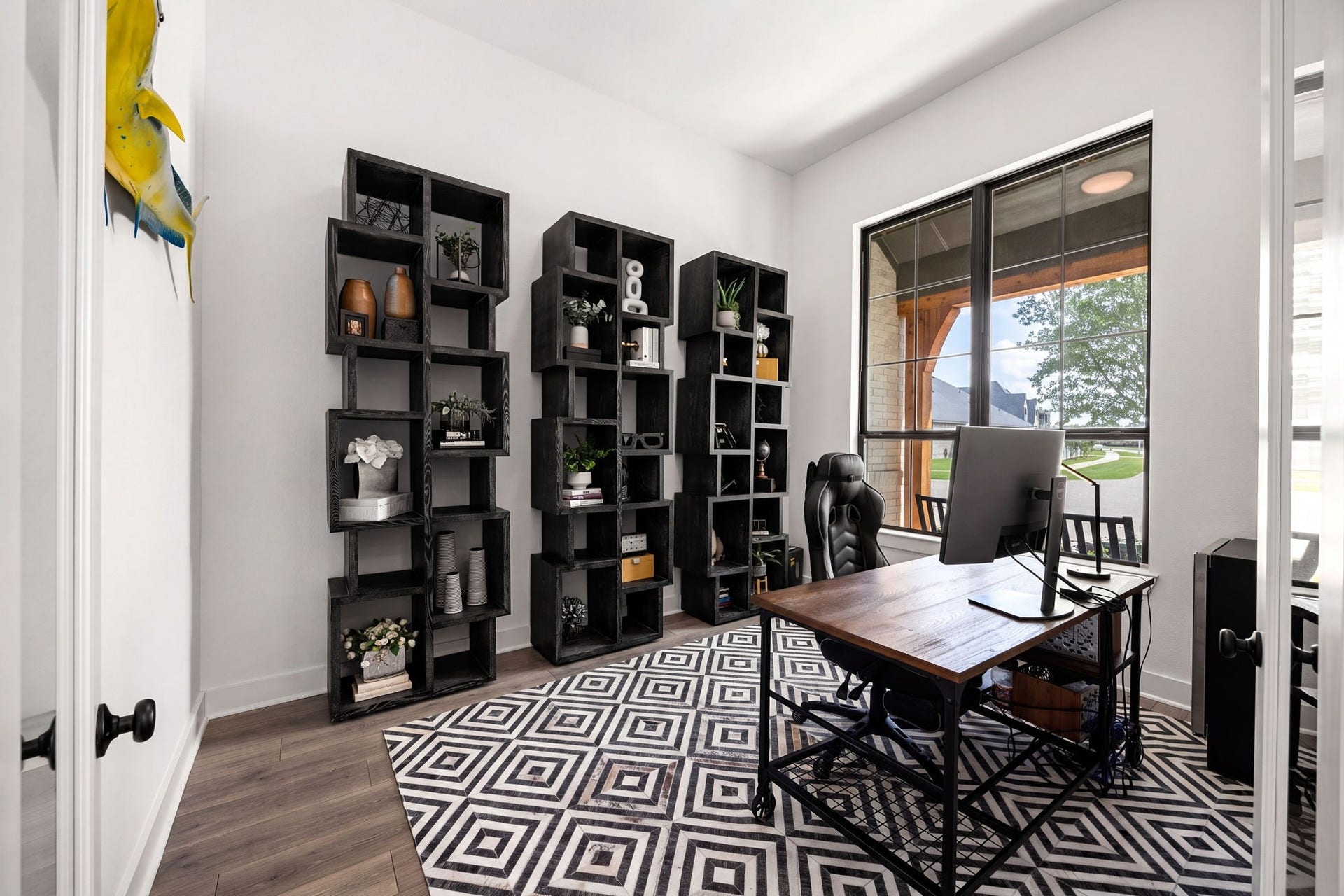 31322 Crescent Hill Drive, Fulshear, TX 77441 An inspiring dedicated home office. High-end wide-plank flooring spans this bright workspace, complete with towering windows framing outdoor views, clean neutral walls, and matte black door hardware.