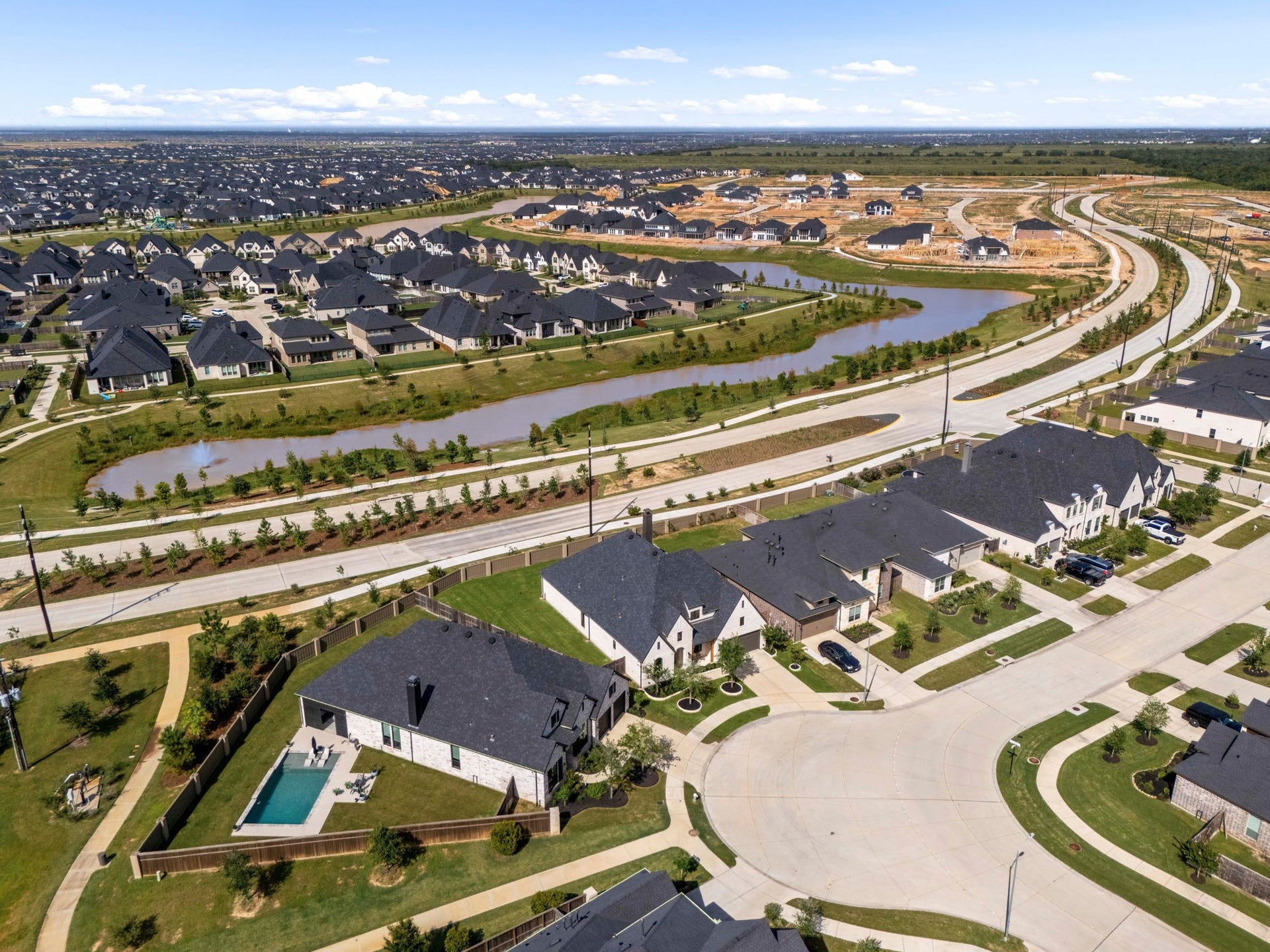 31322 Crescent Hill Drive, Fulshear, TX 77441 An aerial perspective of Cross Creek West. This stunning bird's-eye view highlights the master-planned neighborhood layout, featuring a winding community waterway, manicured green spaces, and neighborhood walking trails just steps from your door.