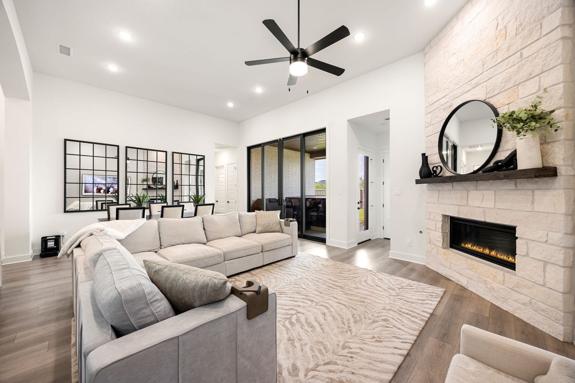 31322 Crescent Hill Drive, Fulshear, TX 77441 Cozy up by the fire. This expansive living space boasts a stunning floor-to-ceiling stone fireplace, soaring ceilings, and a bright, open layout perfect for gathering with loved ones.