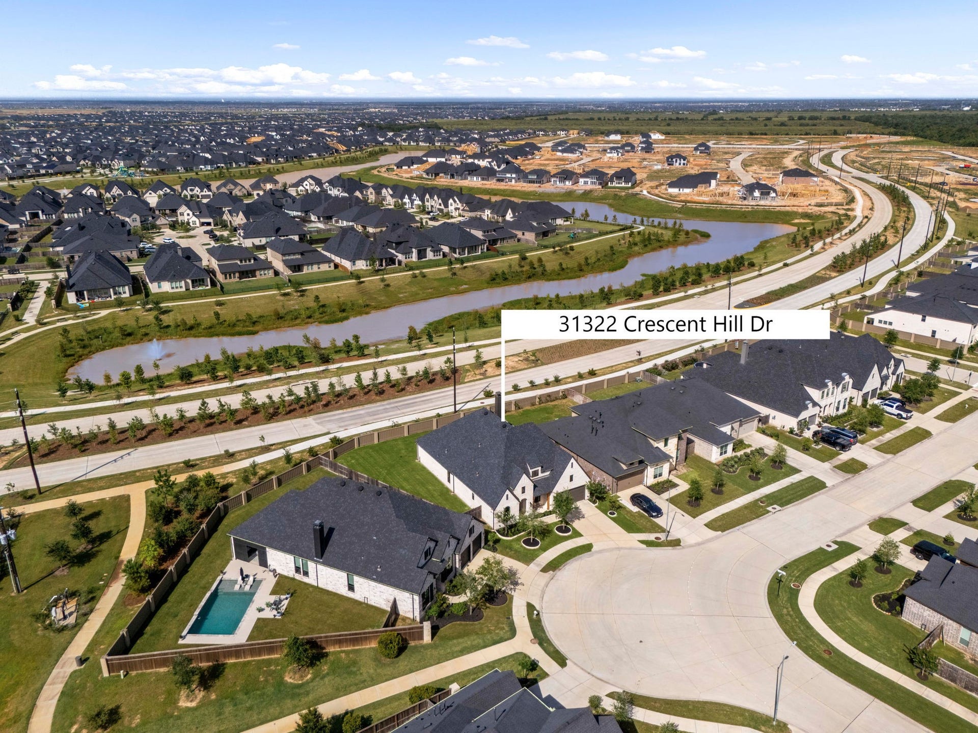 31322 Crescent Hill Drive, Fulshear, TX 77441 Perfect location in Cross Creek West. This clear aerial highlight marks the home's premier position within the community, showcasing its close proximity to the scenic neighborhood waterway, paved walking paths, and beautiful green spaces.