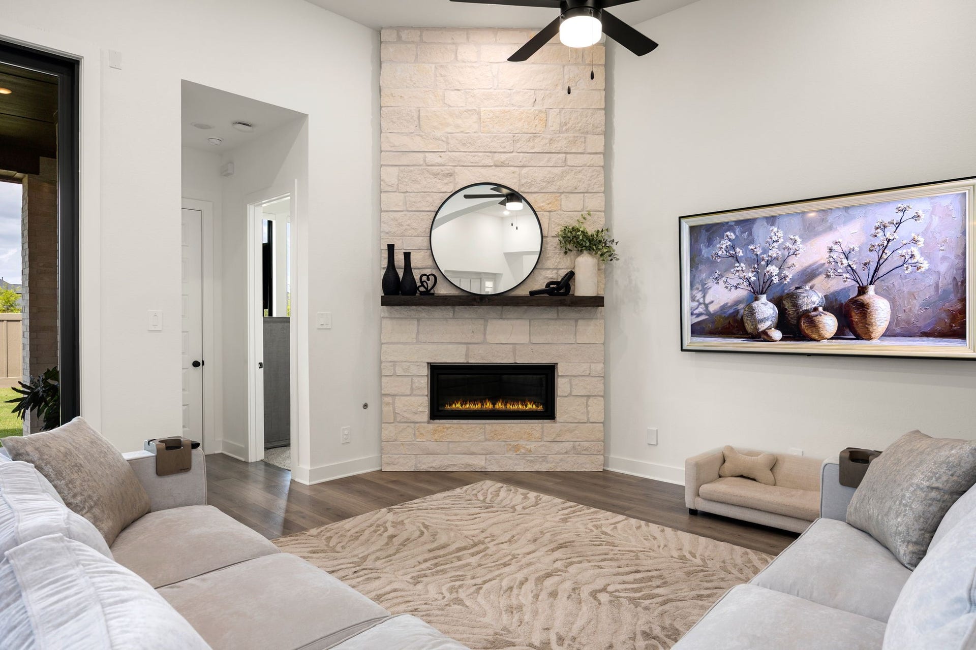 31322 Crescent Hill Drive, Fulshear, TX 77441 A stunning architectural centerpiece. The corner floor-to-ceiling stone fireplace serves as a gorgeous focal point, beautifully complemented by a dark wood mantel, modern ceiling fan, recessed lighting, and premium wide-plank flooring.