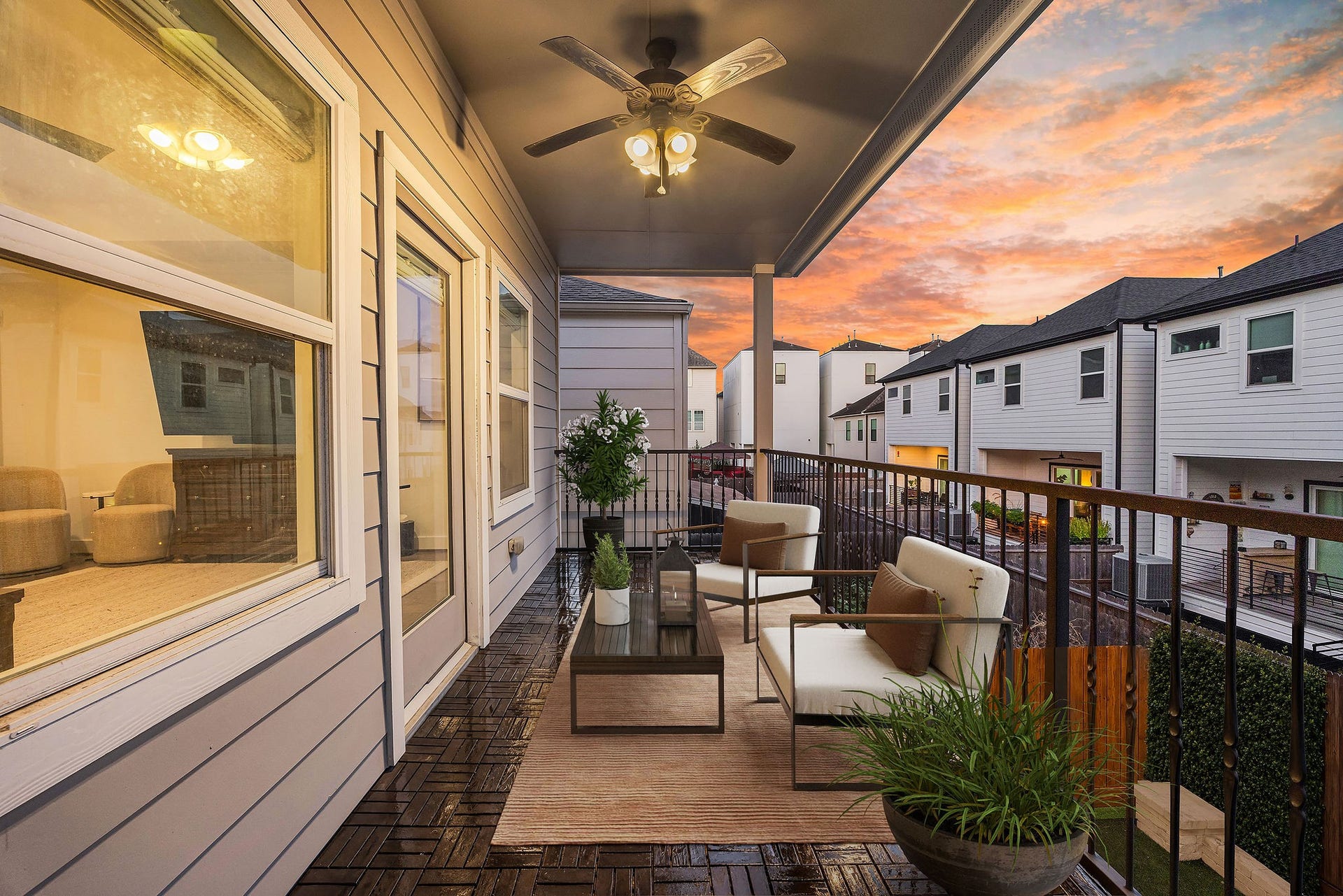 5537 Petty Street, Houston, TX 77007 Charming covered balcony with cozy seating, wooden flooring, and a ceiling fan, perfect for enjoying stunning sunset views.
