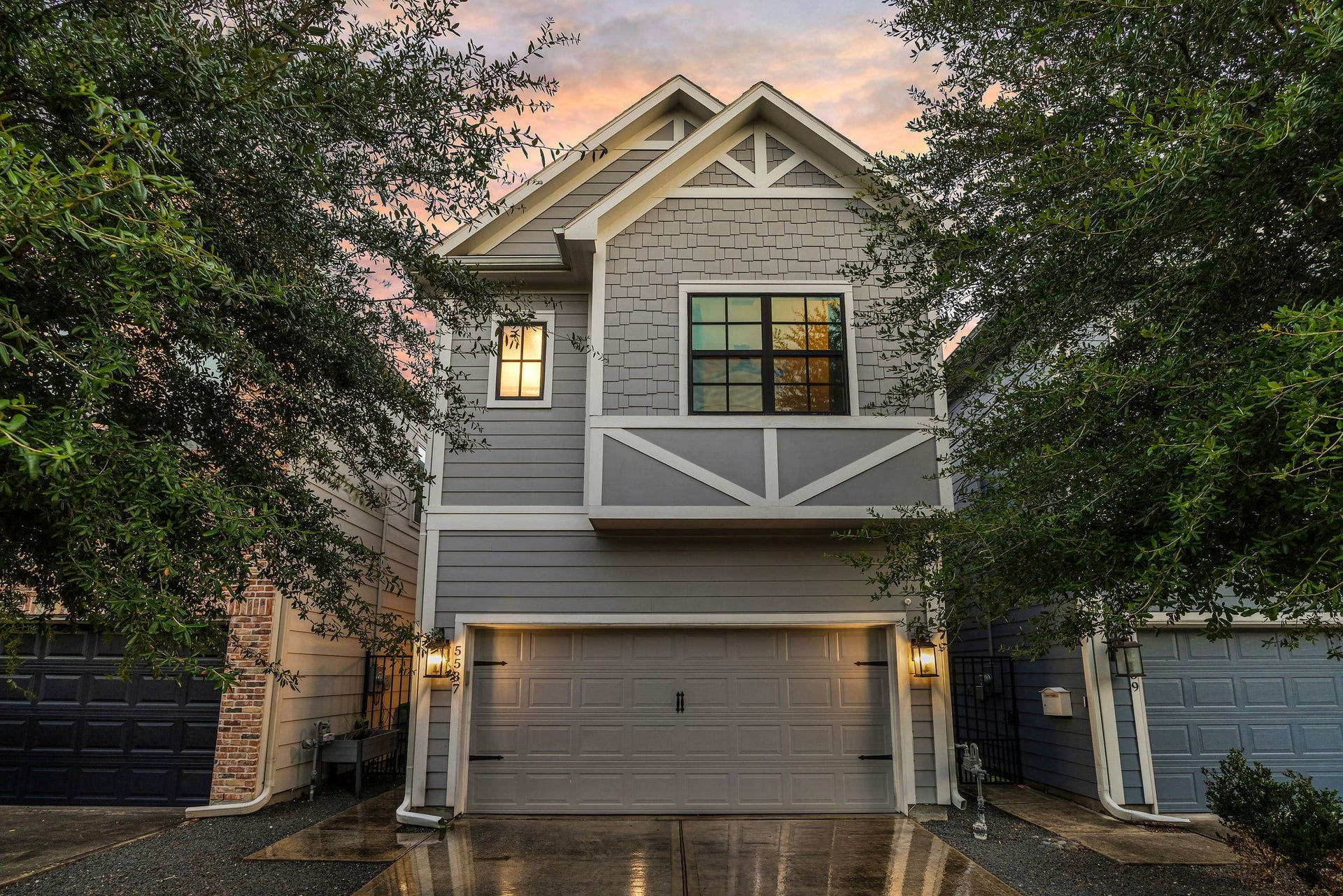 5537 Petty Street, Houston, TX 77007 Charming two-story home with a modern facade, featuring a spacious two-car garage and inviting exterior lighting, nestled among mature trees.