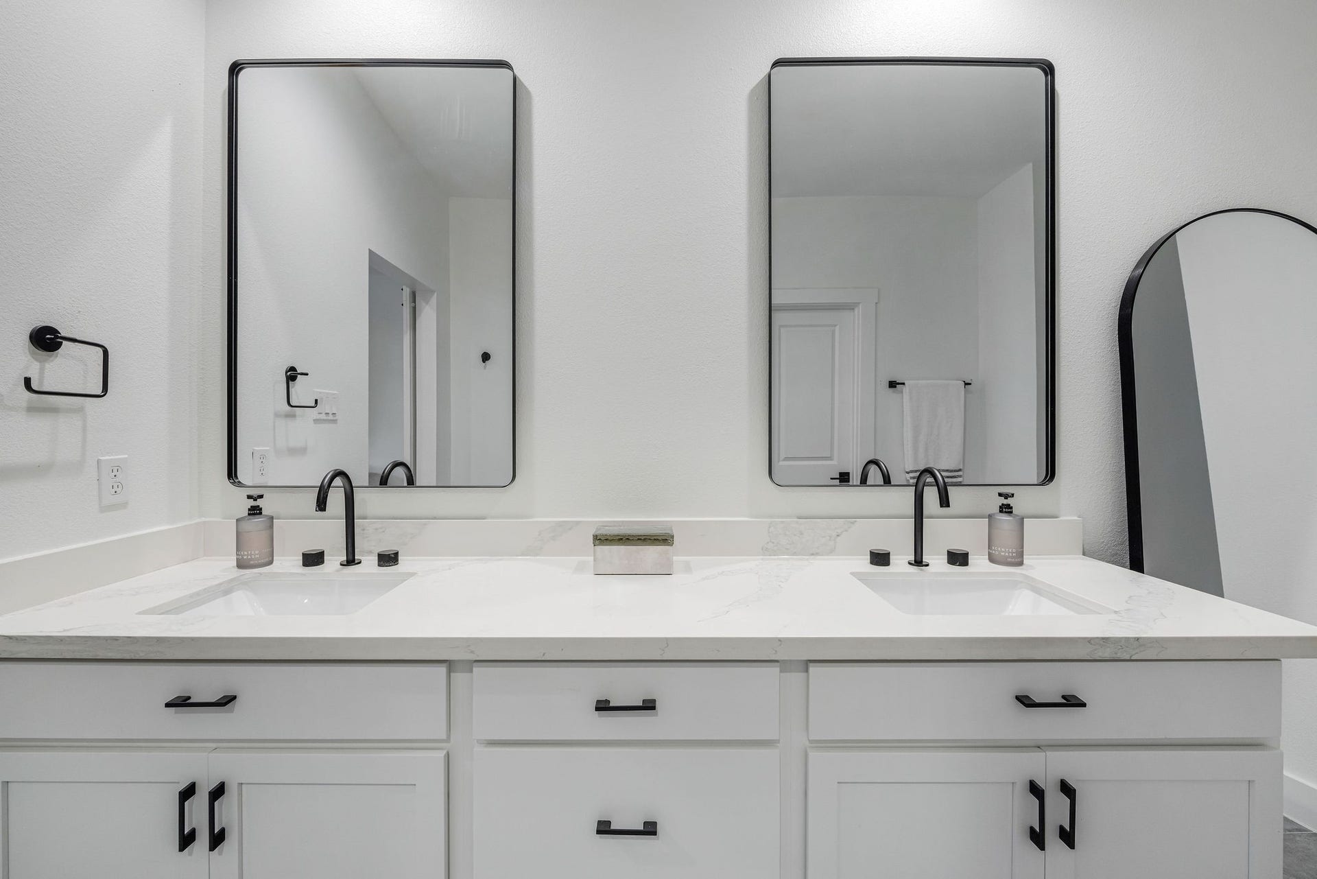5537 Petty Street, Houston, TX 77007 Dual-sink vanity with sleek black fixtures, modern mirrors, and ample storage, set against a crisp white backdrop.